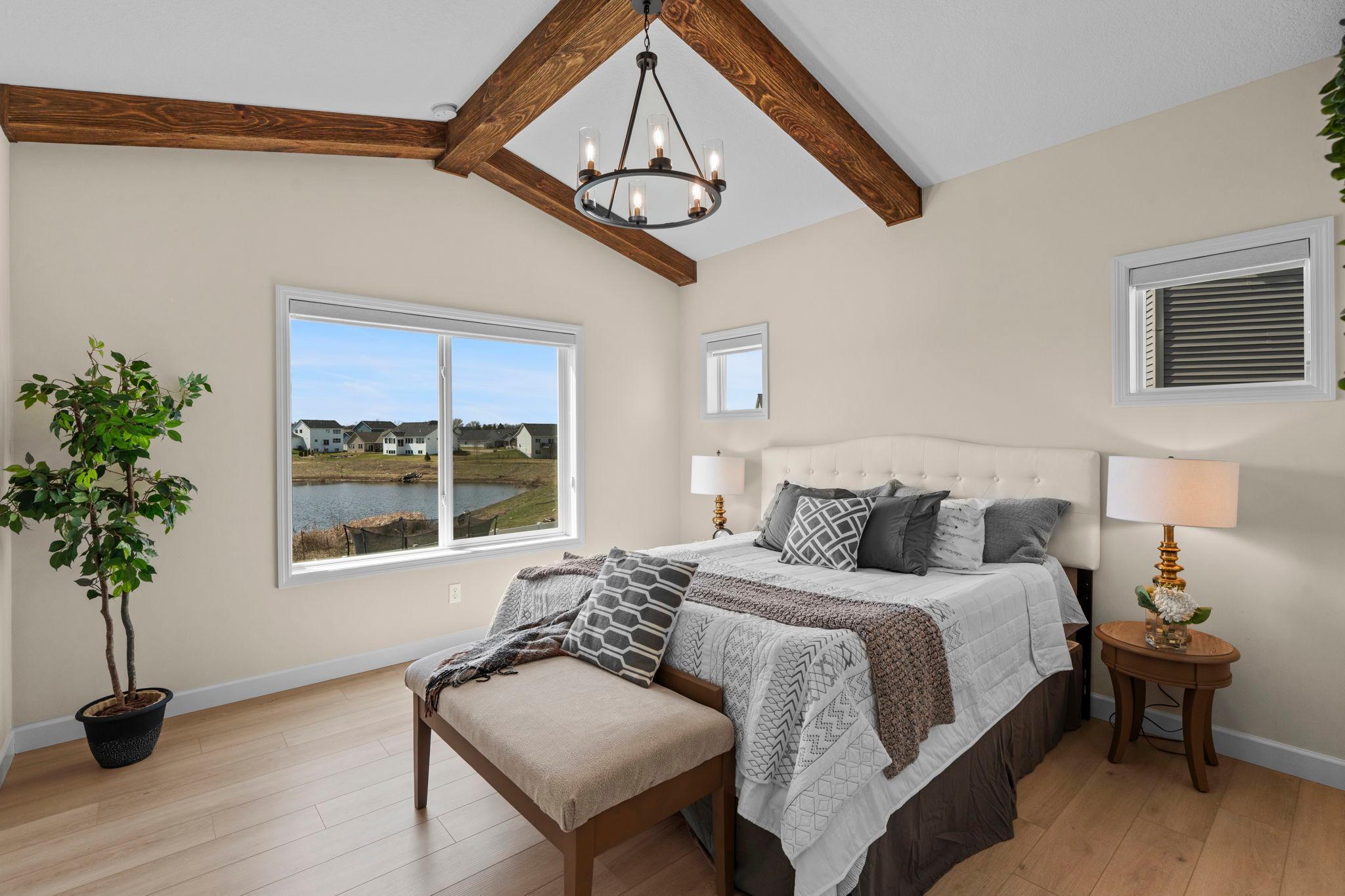Primary bedroom with transom window and vaulted ceiling