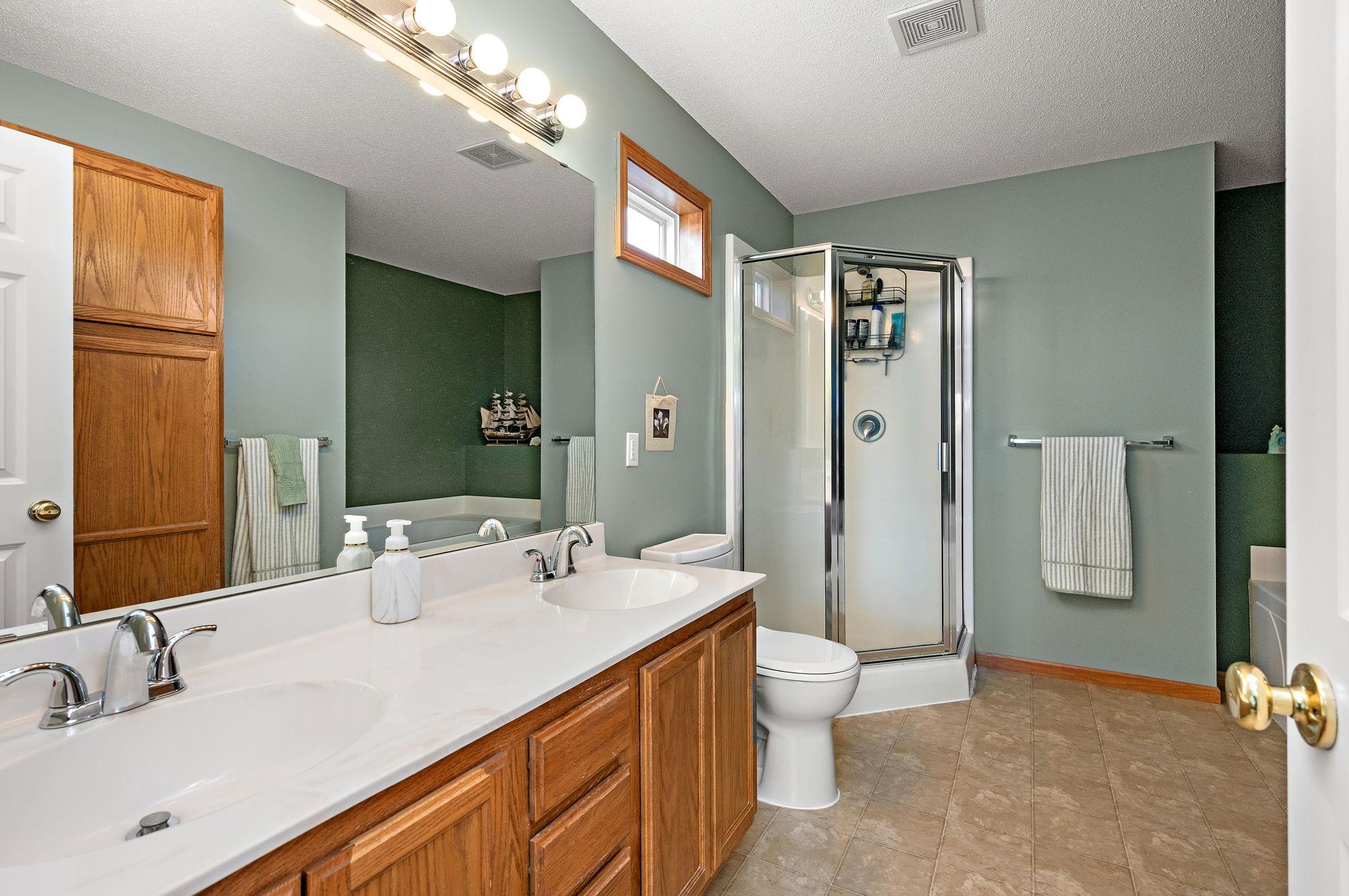 The primary suite serves as a true sanctuary with vaulted ceilings, a large walk-in closet, and a spa-like ensuite bathroom featuring a double vanity, a separate soaking tub, and a walk-in shower