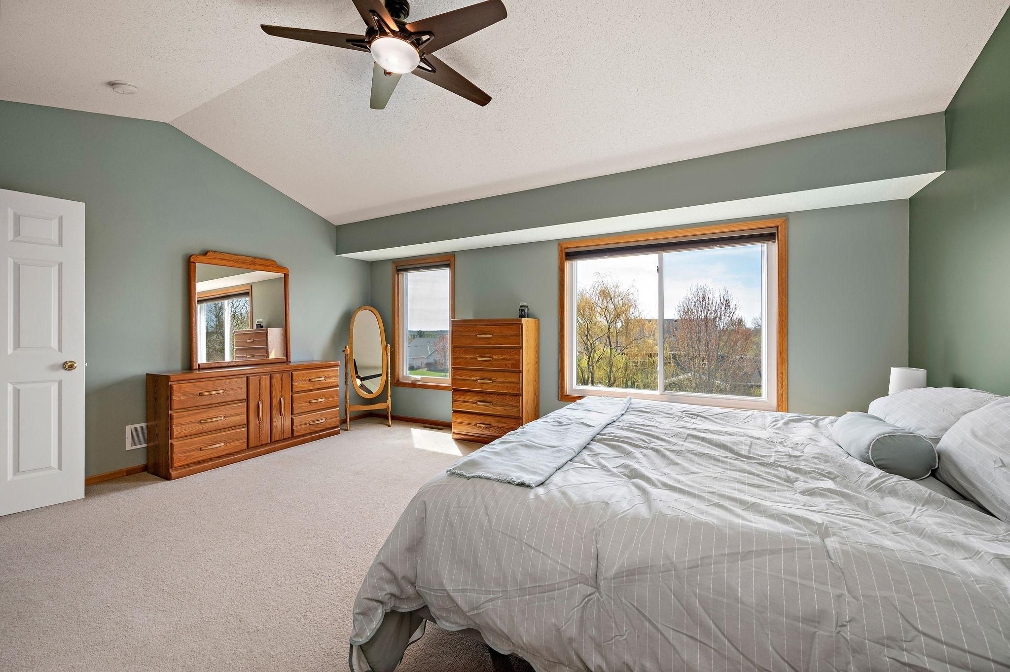 The primary suite serves as a true sanctuary with vaulted ceilings, a large walk-in closet, and a spa-like ensuite bathroom featuring a double vanity, a separate soaking tub, and a walk-in shower