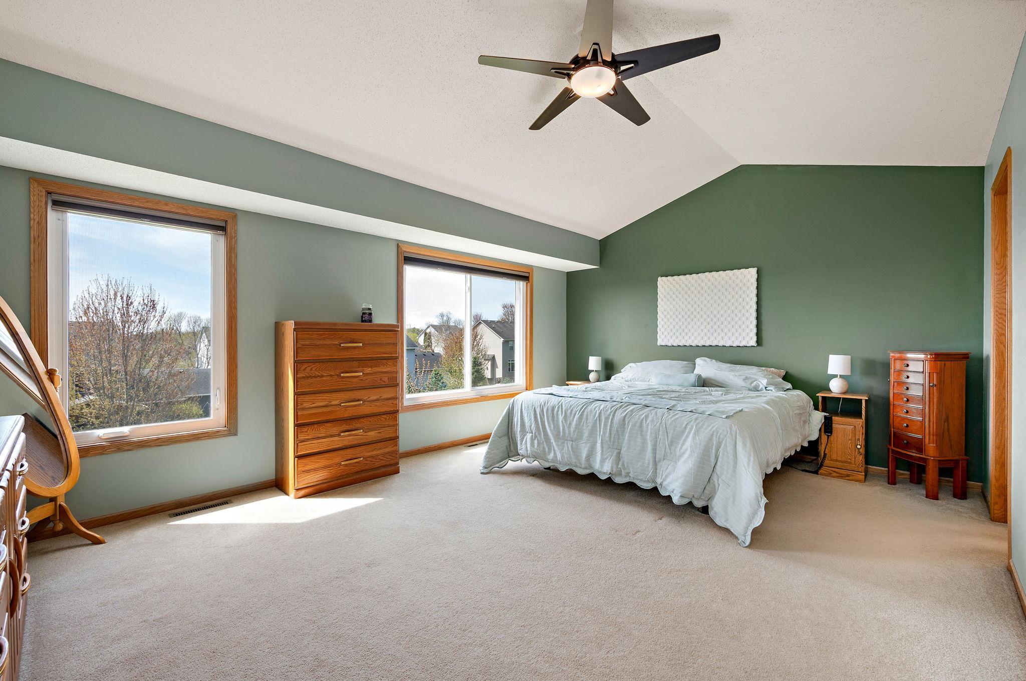 The primary suite serves as a true sanctuary with vaulted ceilings, a large walk-in closet, and a spa-like ensuite bathroom featuring a double vanity, a separate soaking tub, and a walk-in shower