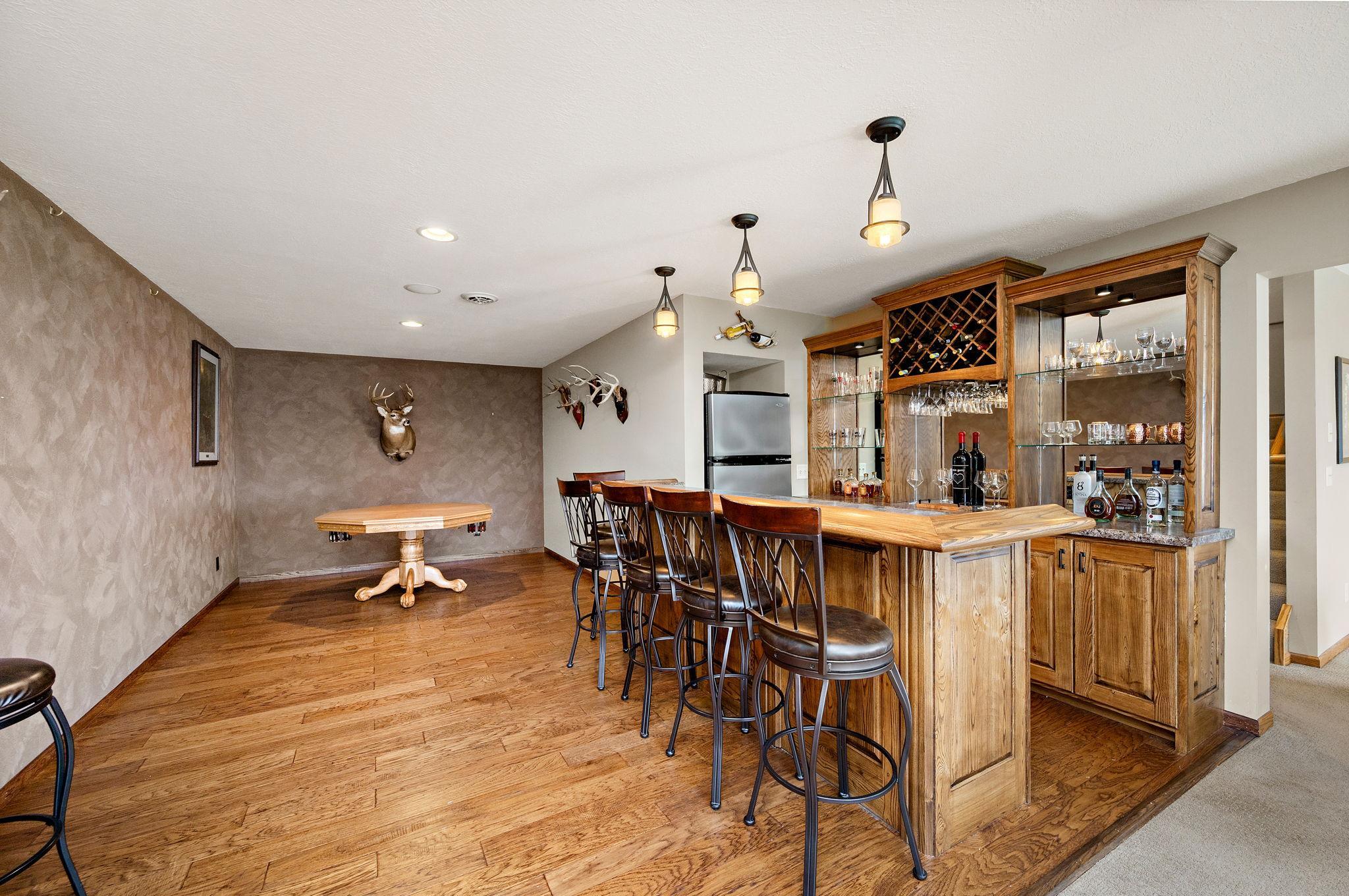 The lower level is built for entertaining, showcasing stylish knock-down ceilings and a custom bar area