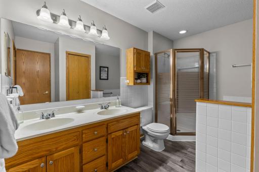 The upper-level primary walk-through bathroom features a walk-in shower and double vanity.