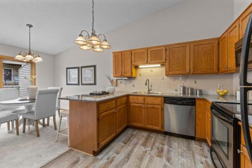 Vaulted ceilings extend into the kitchen, where a large skylight fills the space with natural light.