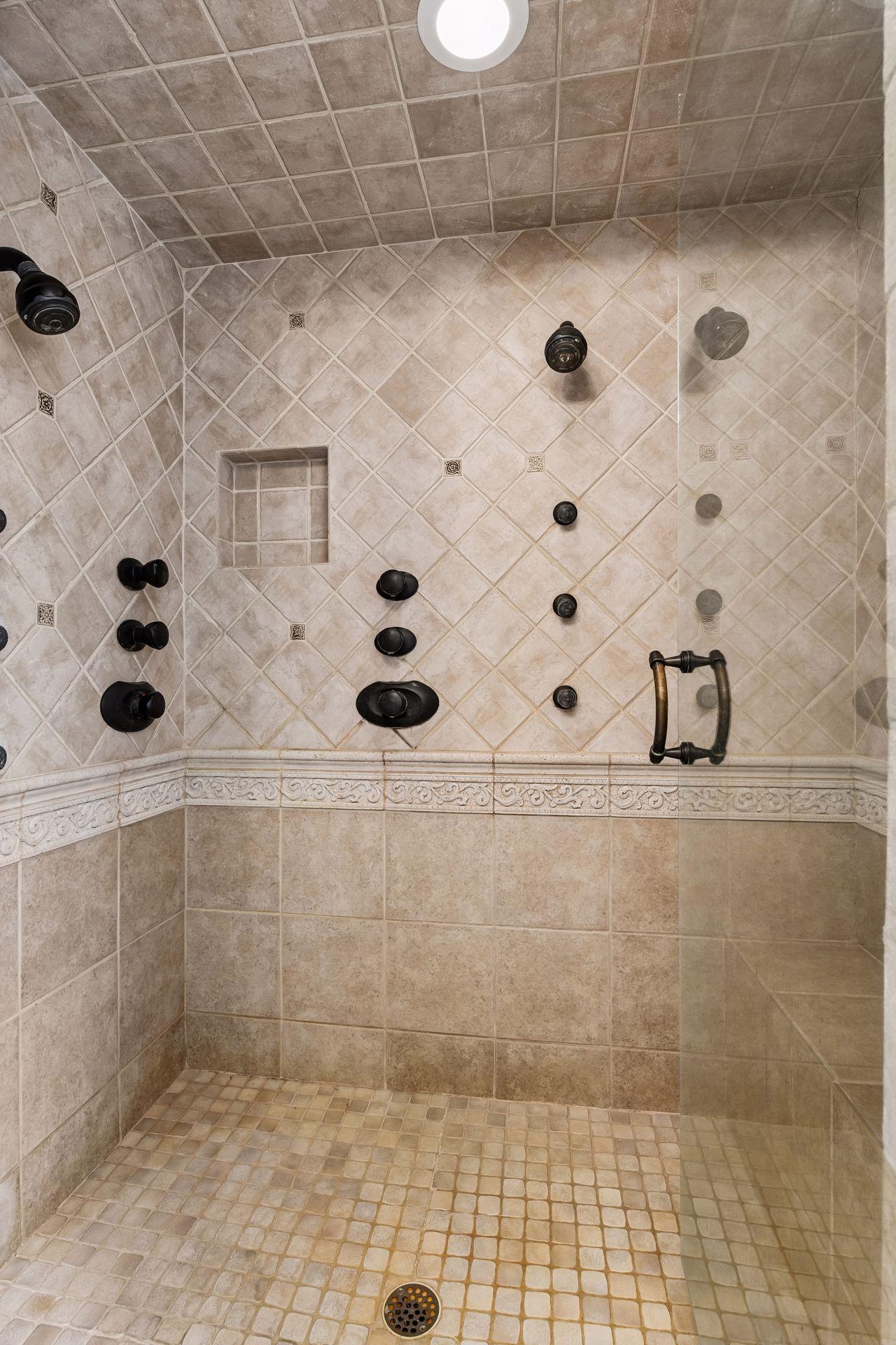 Custom tiled primary shower with multiple shower heads, handle et al! Pure Luxury!