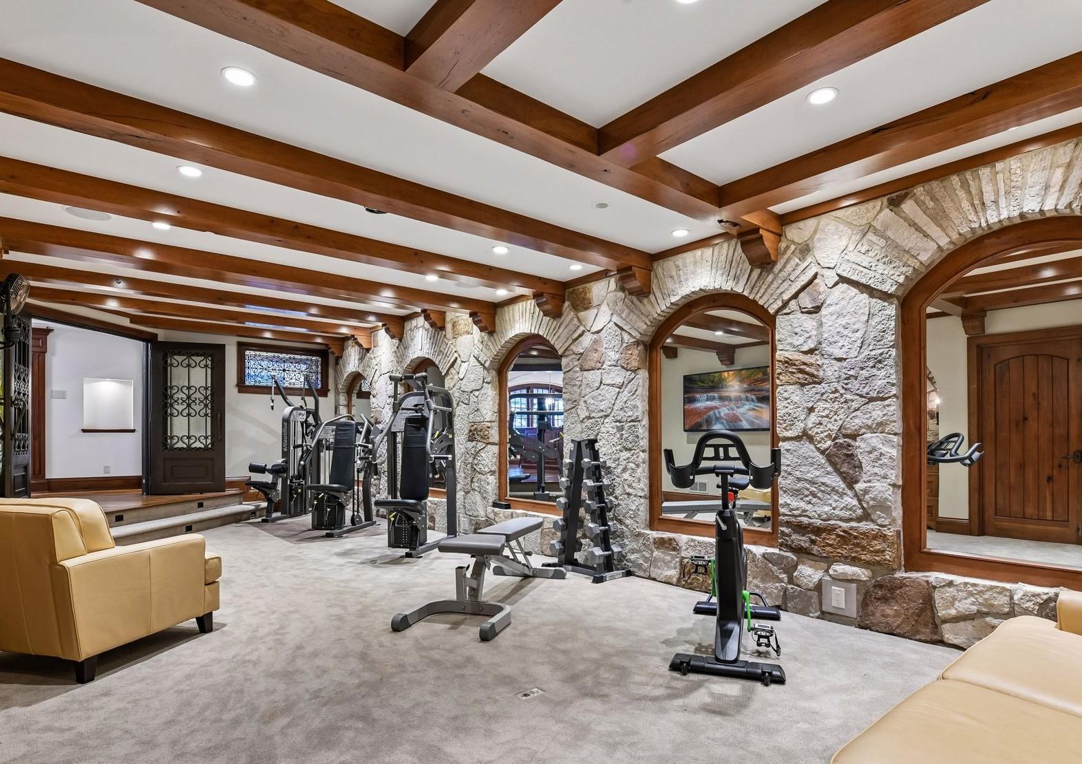 Comfortably carpeted, 2 televisions, stone walls with wood beams and brackets. Plenty of room for your favorite excercise equipment.