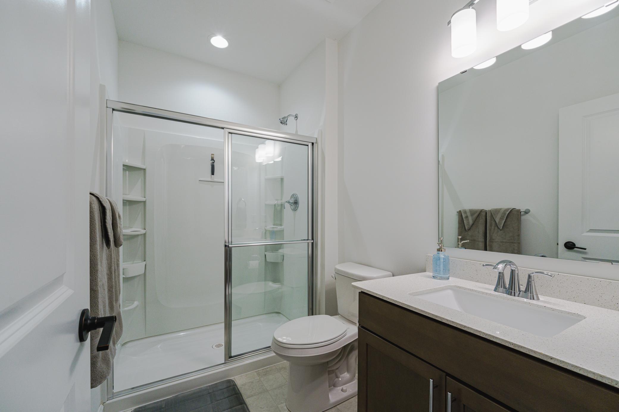 The lower level 3/4 bath has a quartz countertop.