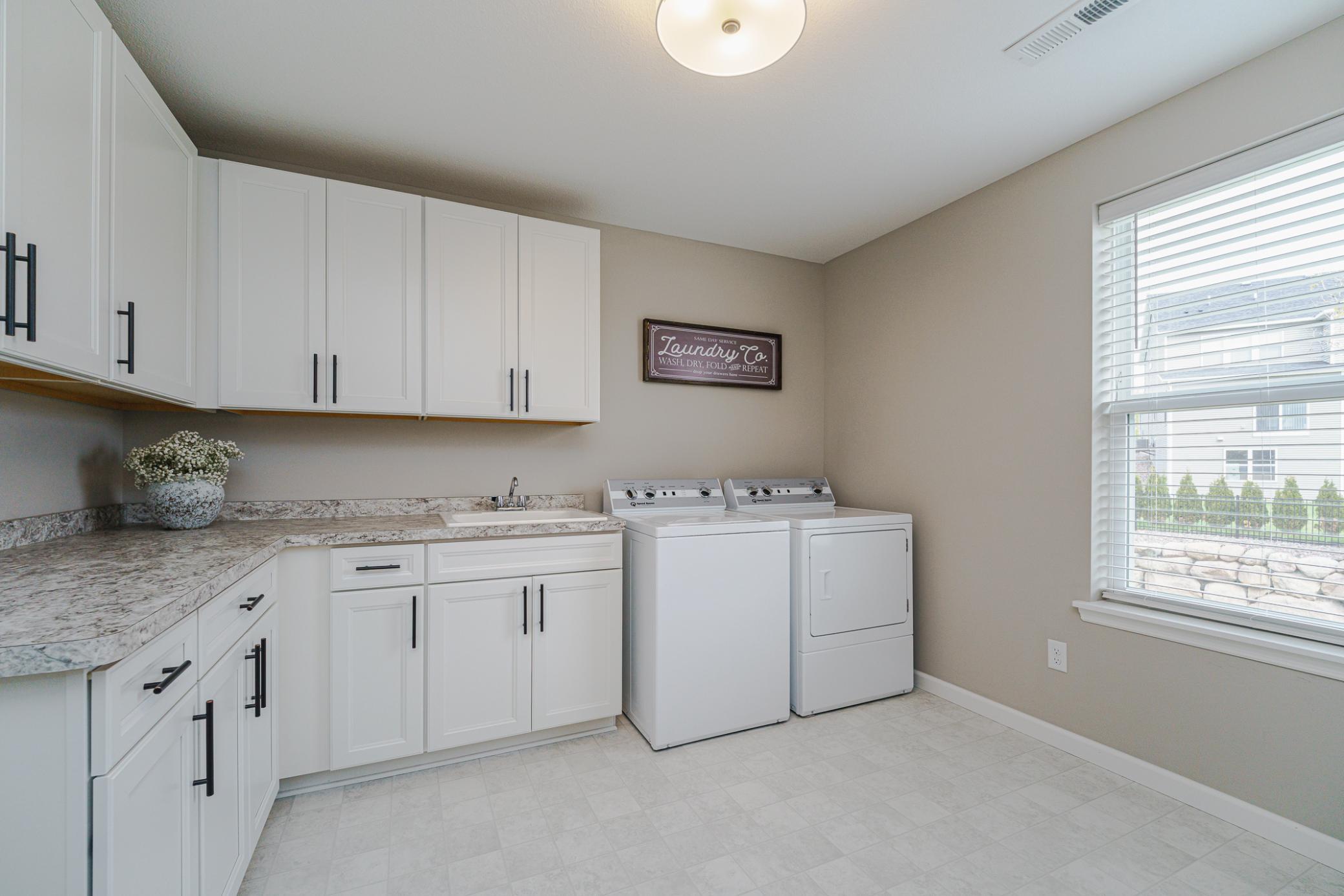 The original floor plan called for a loft, which the seller converted into a HUGE laundry room with large windows, cabinetry, a folding counter and a sink.