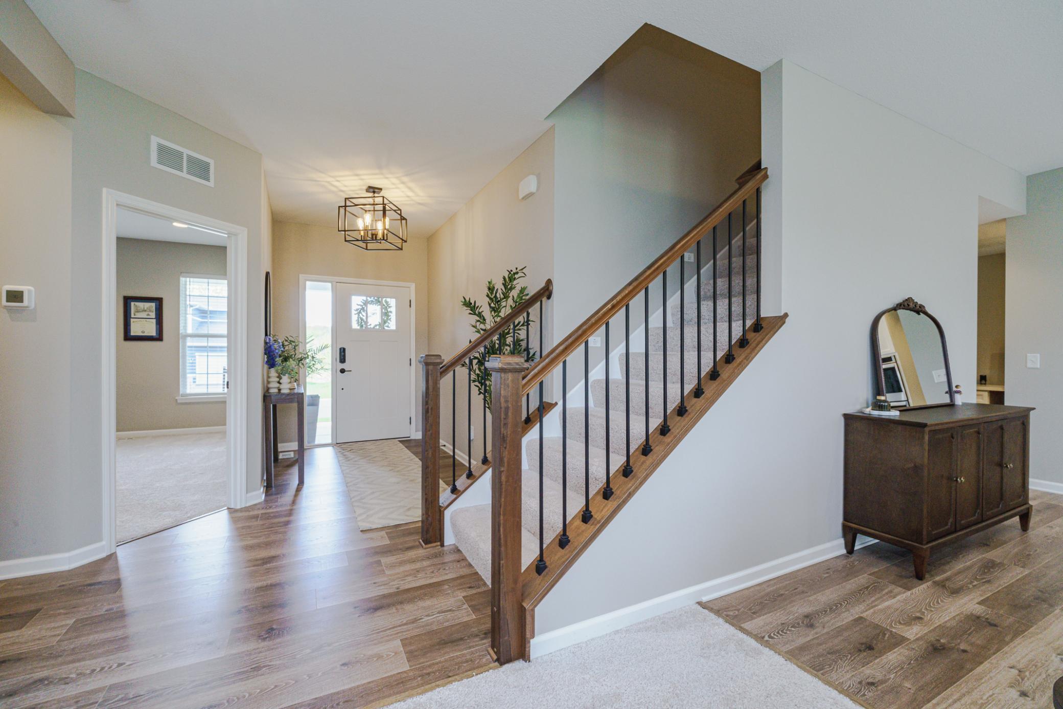 The main entrance is beautiful, with iron balusters on the staircase, LVP flooring, update lighting, and large windows that bring in light!