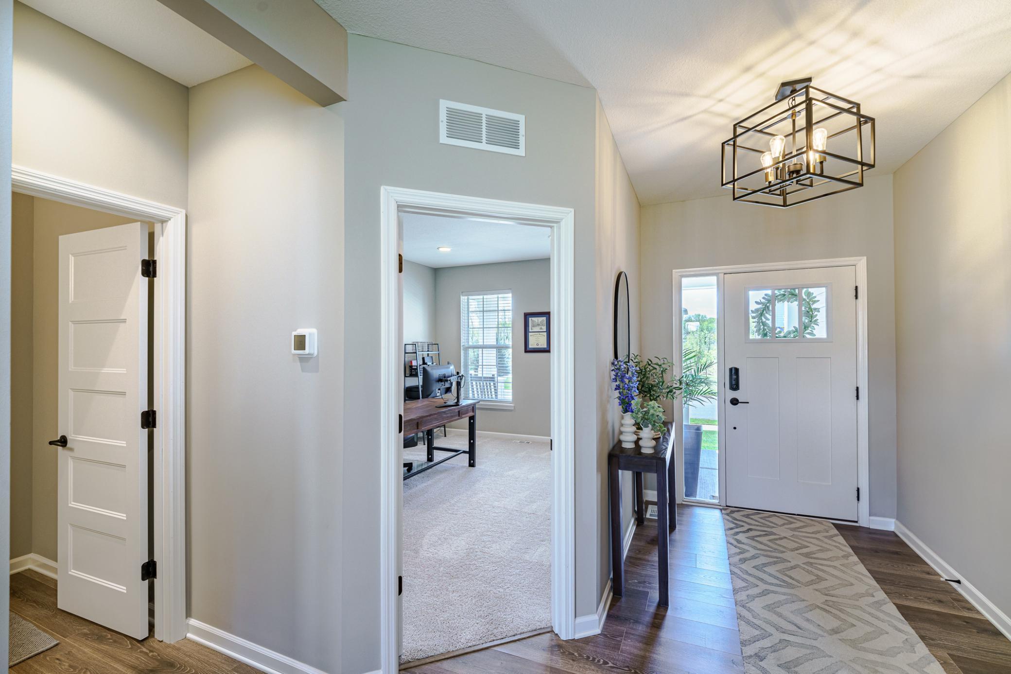The main entry hall is wide and receives wonderful southern light. The LVP flooring coordinates with other main living spaces. A HUGE office lies off the entry.