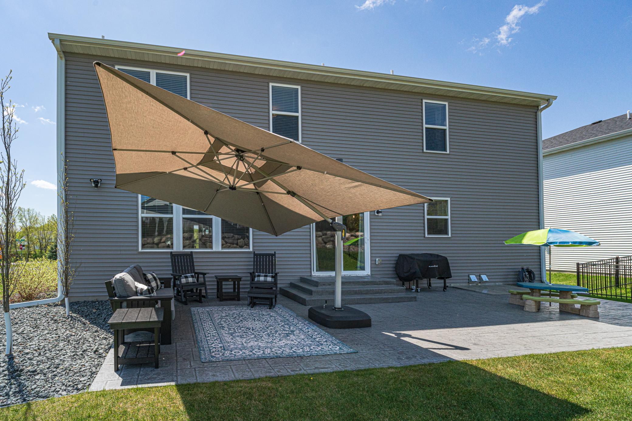 The seller added over $50,000 in exterior landscaping including this huge 14x36 patio with surrounding stone, plantings, and lots of outdoor space to relax and play!