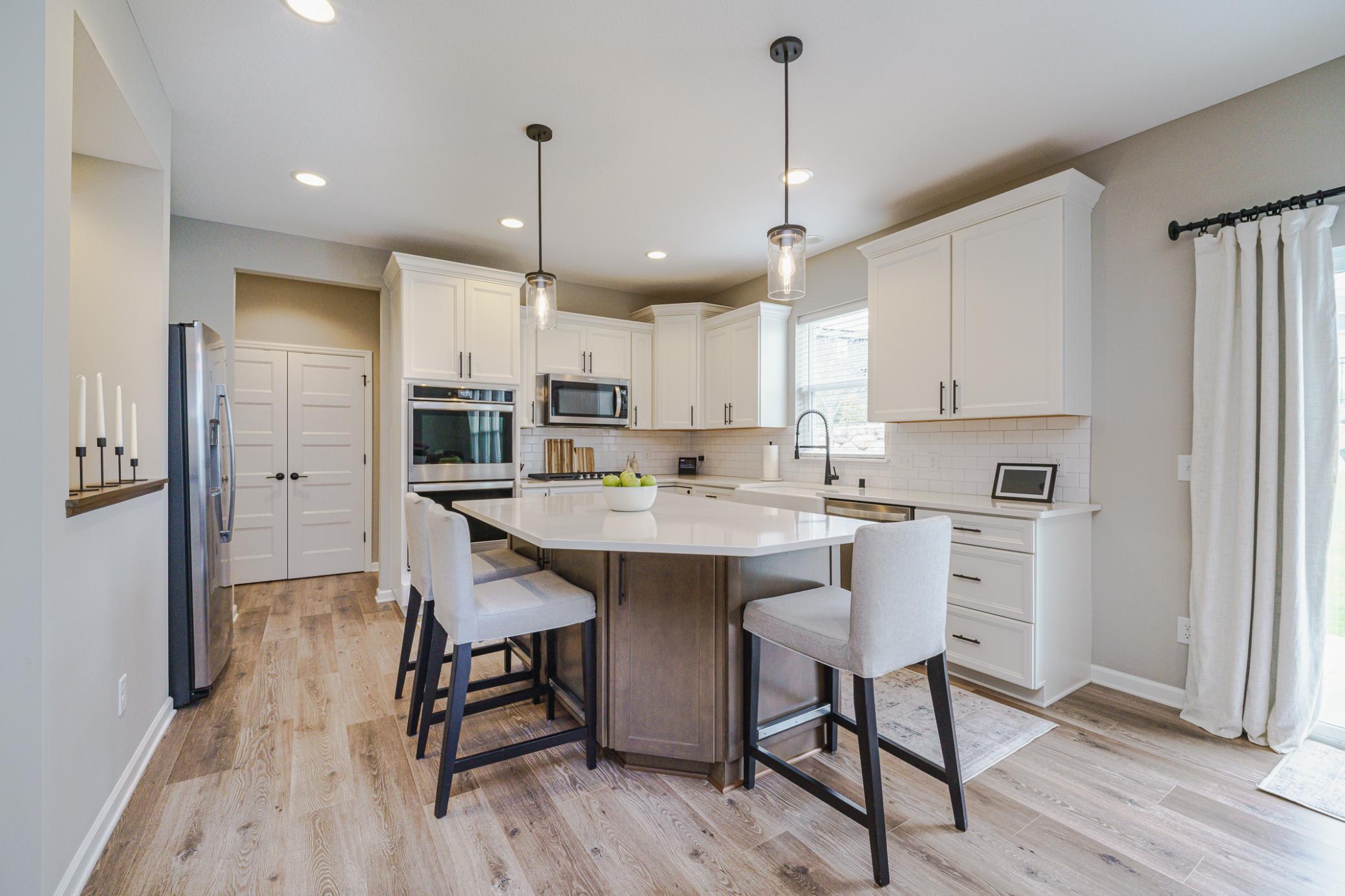 The kitchen is crisp and clean, with 42” staggered white cabinetry with soft close drawers and roll-out shelves. The kitchen is classic yet fresh, with a neutral and clean style.
