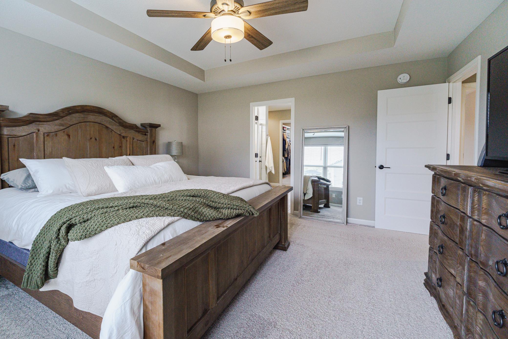 The primary suite has a tray ceiling with a ceiling fan, as well as a private 3/4 bath.