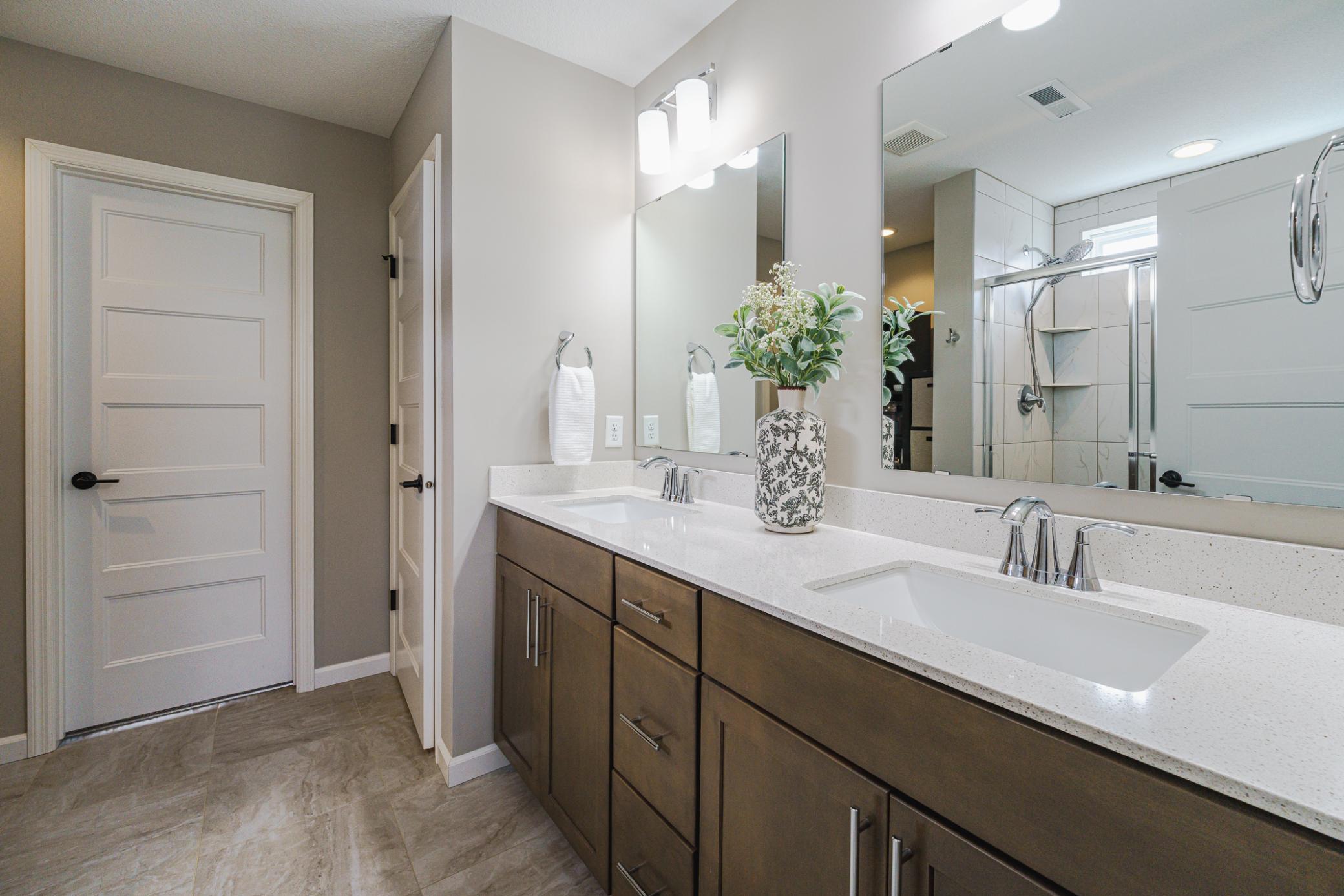 The bathroom has five-panel doors, a dual-sink vanity with quartz counters, and a private commode.