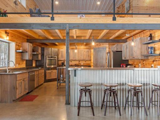 Custom kitchen with pantry storage, dishwasher, stove, refrigerator & microwave.