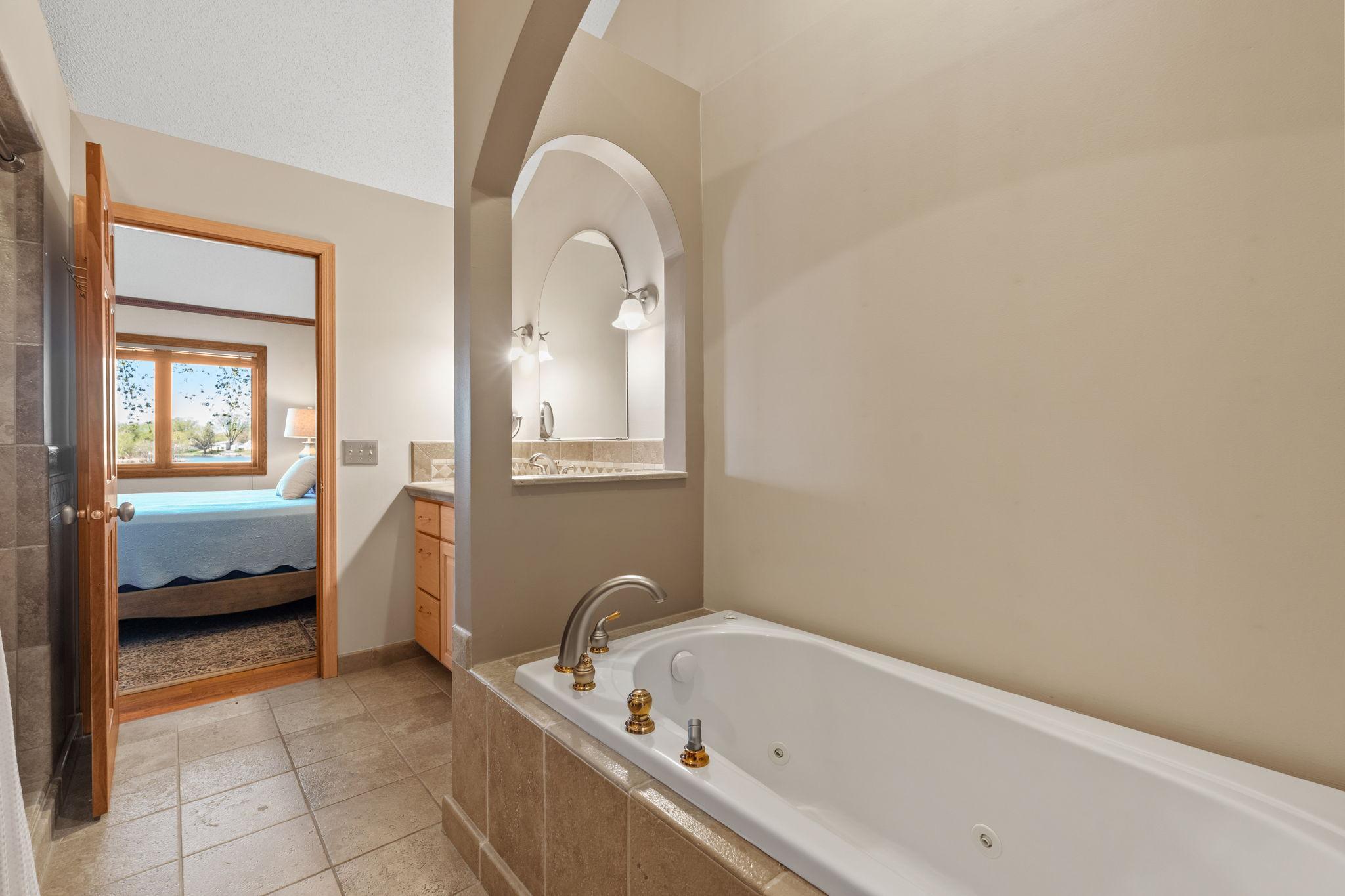 The soaking tub offers a relaxing escape, perfect for unwinding after a long day in a calm and comfortable setting.