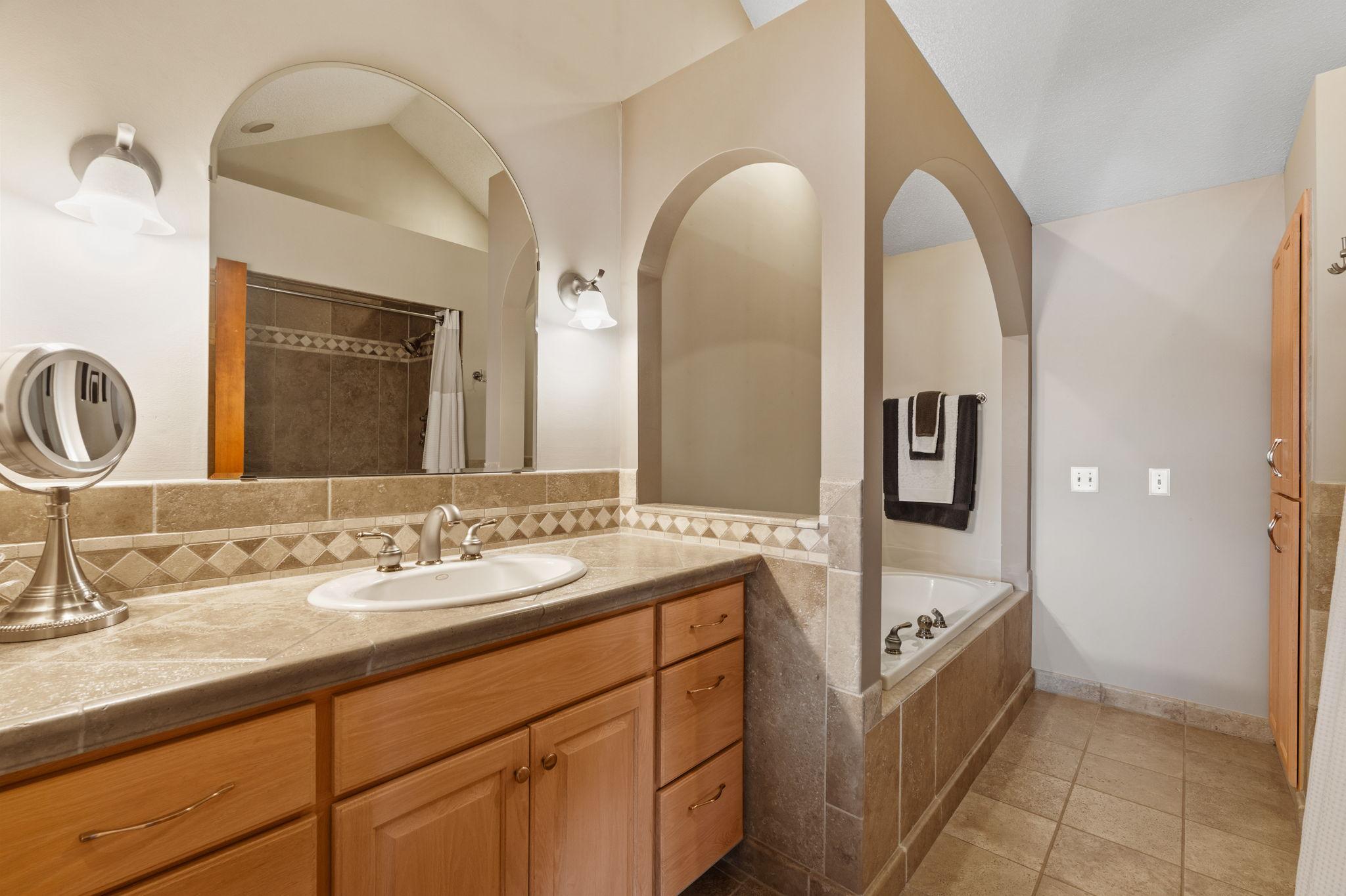 The primary bathroom includes a separate tub and shower, offering both relaxation and convenience in a well-designed space.