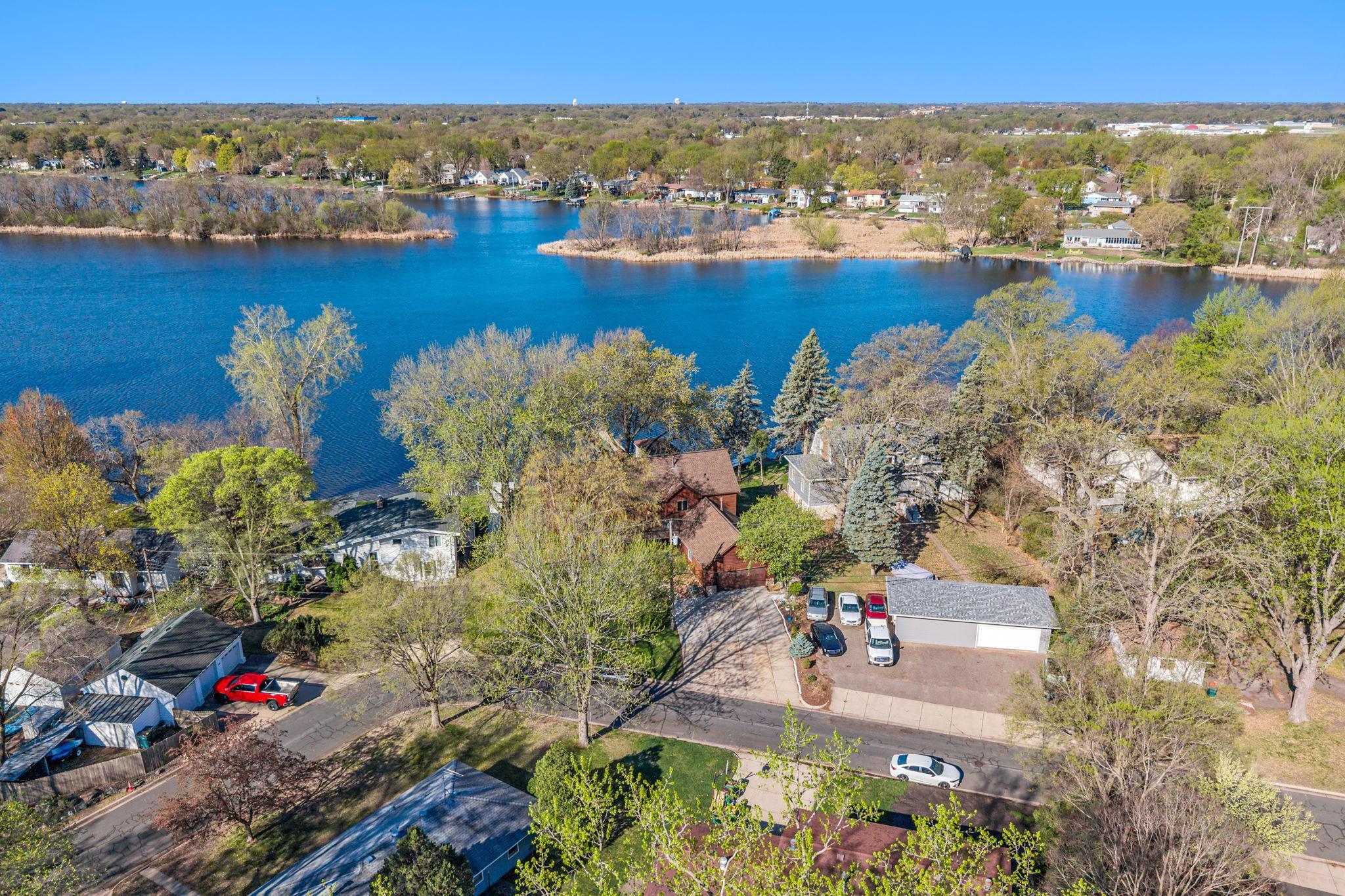 An aerial view captures the home’s stunning location along Upper Twin Lake, showcasing its full setting and surroundings.