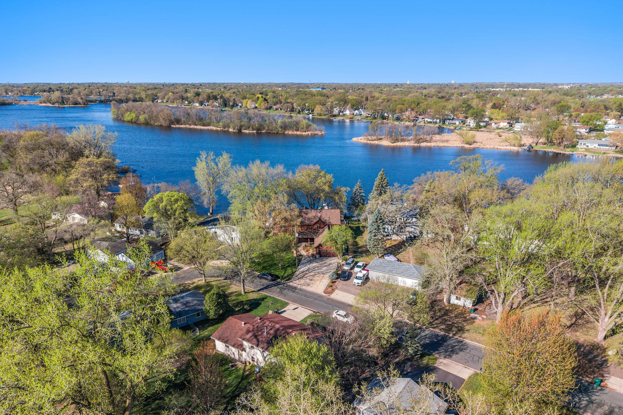 An aerial view captures the home’s stunning location along Upper Twin Lake, showcasing its full setting and surroundings.