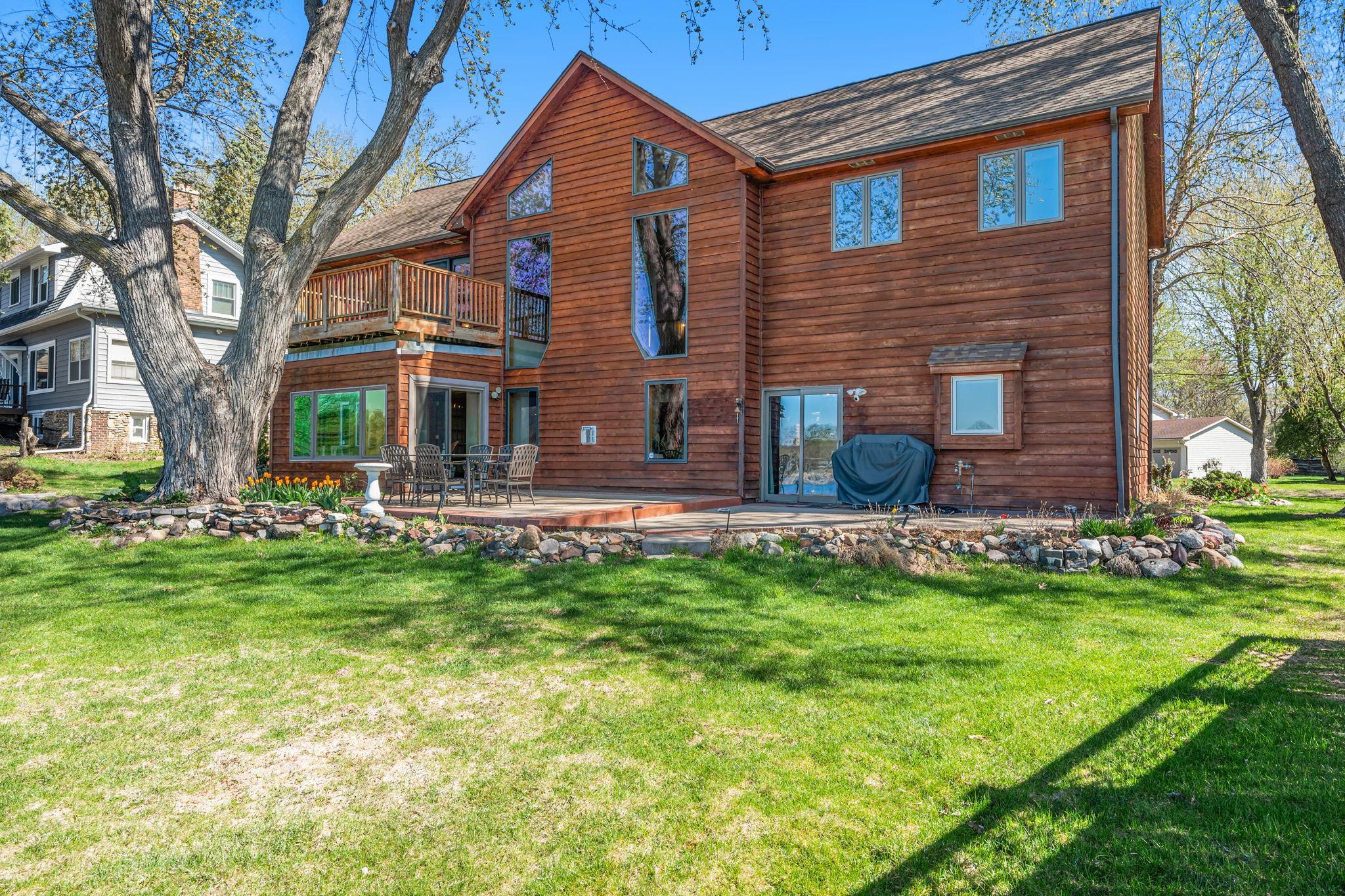 The rear exterior highlights the home’s connection to outdoor living, with easy access to the patio and lakefront.