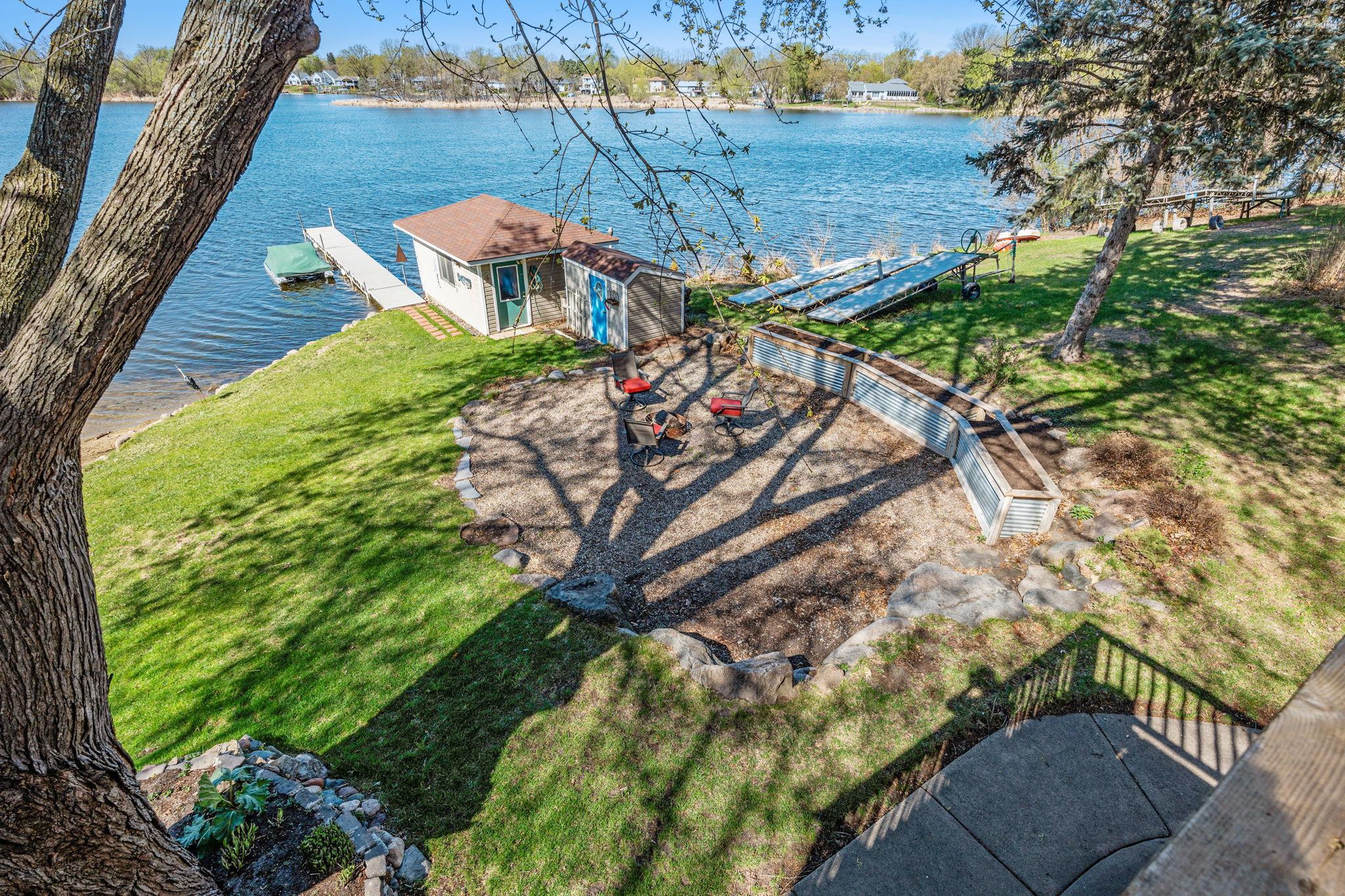 From the deck, take in views of the backyard, boathouse, and lake beyond. This perspective highlights the home’s unique waterfront setting.