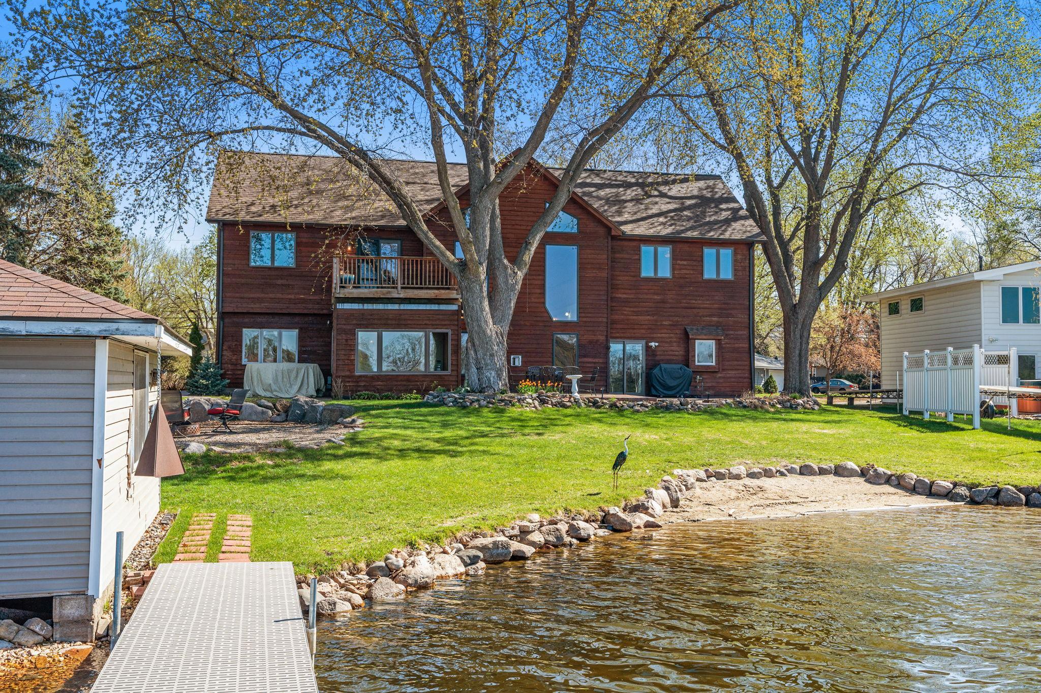 Another dockside perspective highlights the home’s connection to the water and its expansive outdoor spaces.