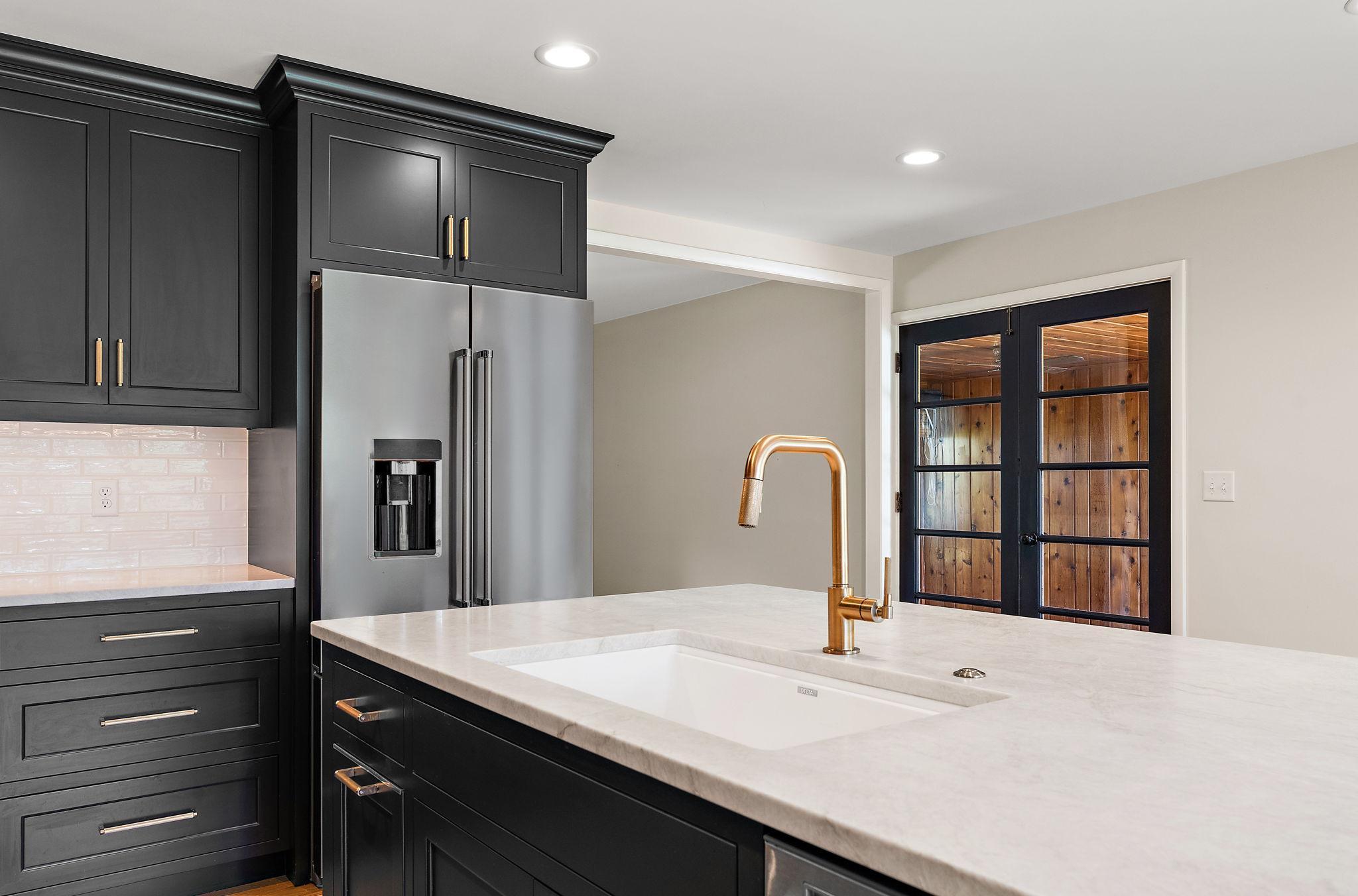 You will find Quartzite natural stone counters throughout the kitchen & a Prizzo Luxe Gold Litze Pulldown Spray Faucet. Quartzite grew up as soapstone and was forged by intense heat and pressure. It is incredibly hard (harder than glass).