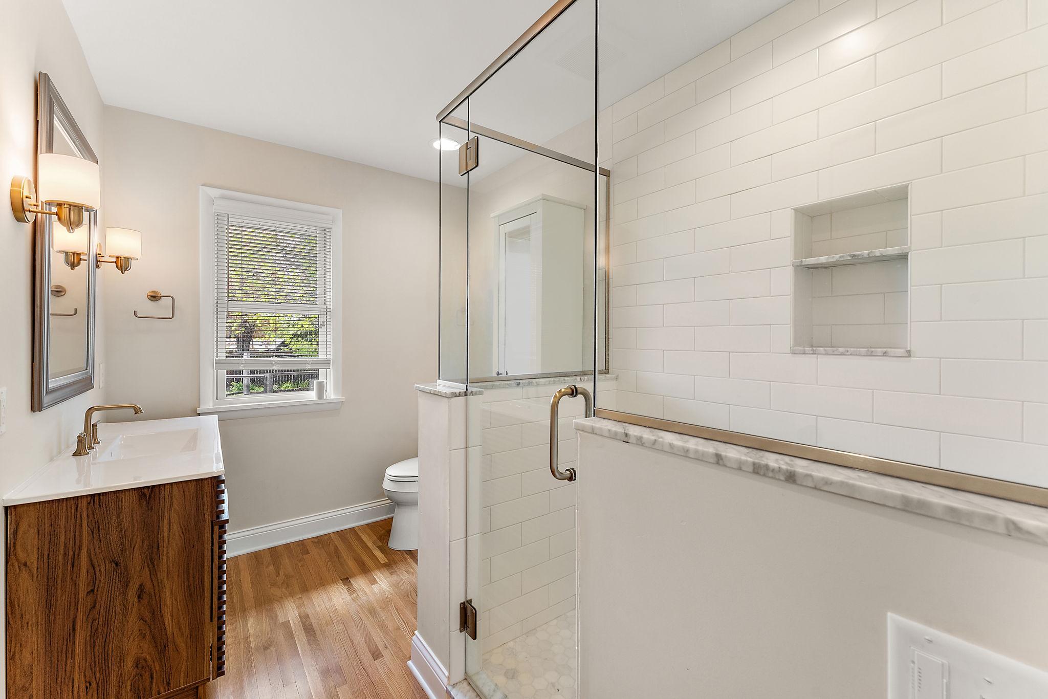 The primary private bath was added in the 2024 addition. Note the custom glass enclosed shower.