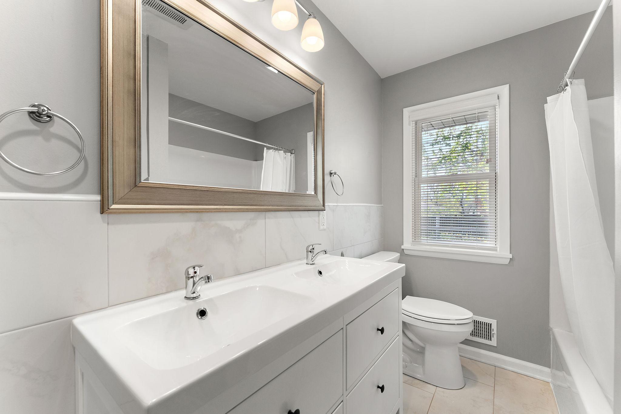 The second bathroom on the main floor features a double sink & bathtub.