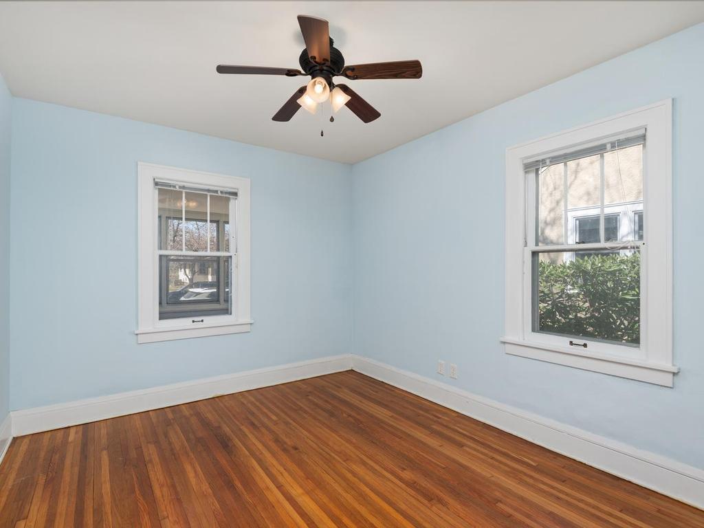 Main level Bedroom 1 has hardwood floor and a ceiling fan.