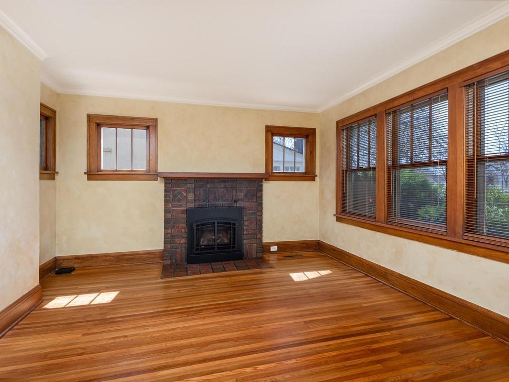 Living Room has beautiful original woodwork, hardwood floor, and a brick gas fireplace.