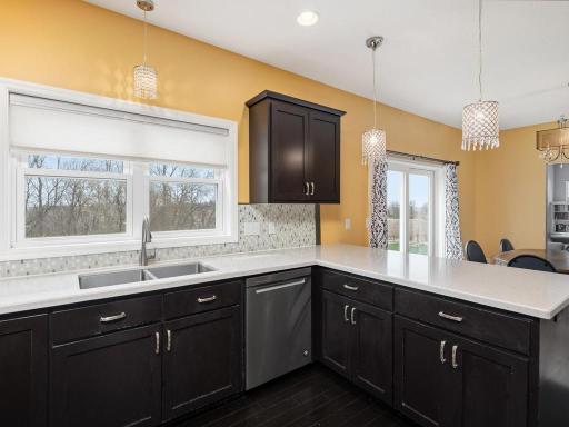 Wonderful south-facing windows over the sink brightens the kitchen with natural light, while the pendant lighting provides a stylish element!