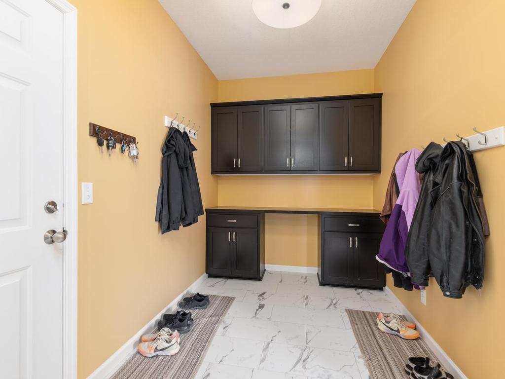 The spacious Mudroom has waterproof composite core flooring for ease of clean-up and durability, while the built-ins provide storage & the coat hooks provide a great hub for coming & going!