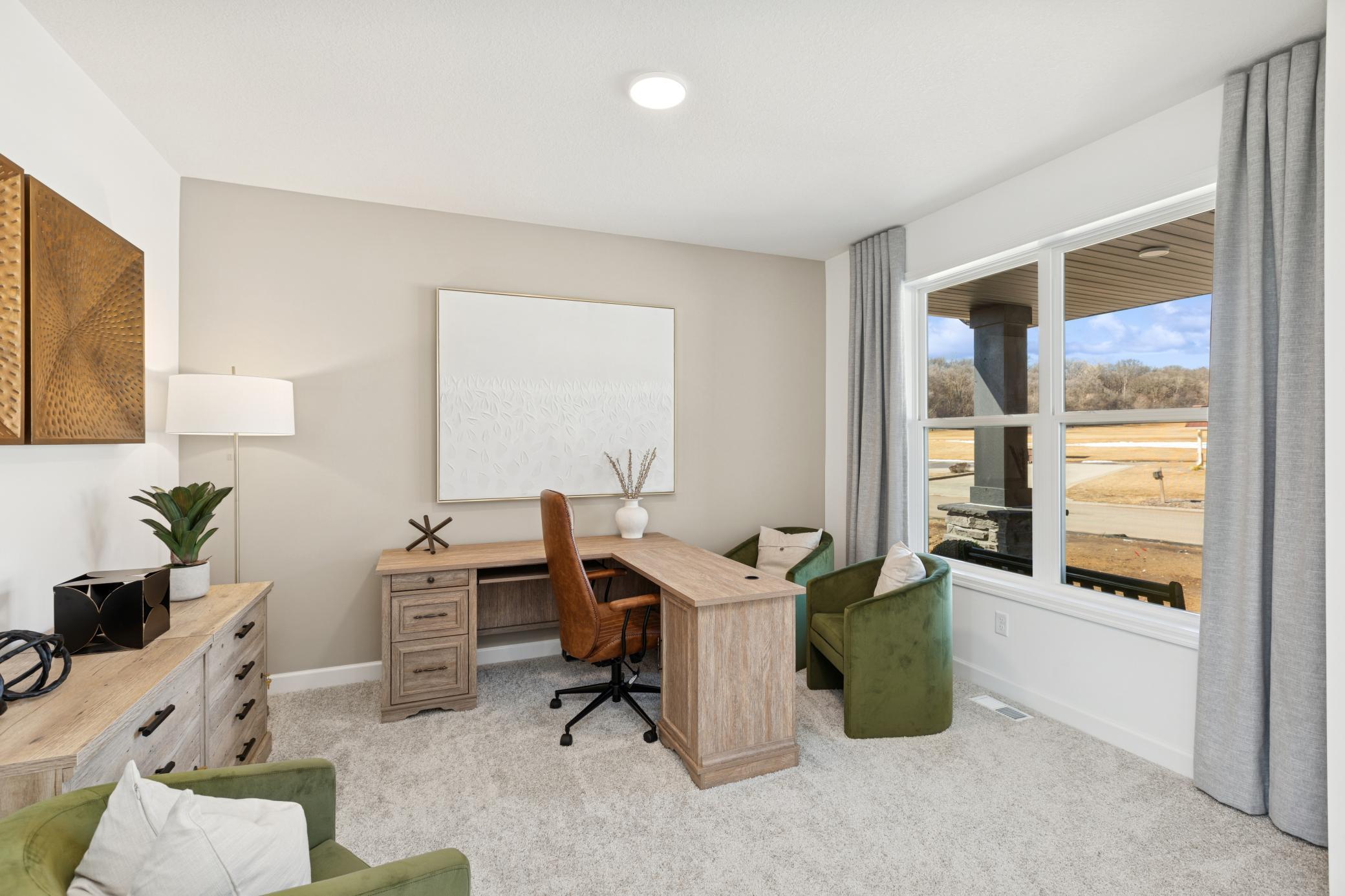 (Photo of Actual Model Home) A versatile flex space situated off the foyer is ideal for a home office, as shown here.