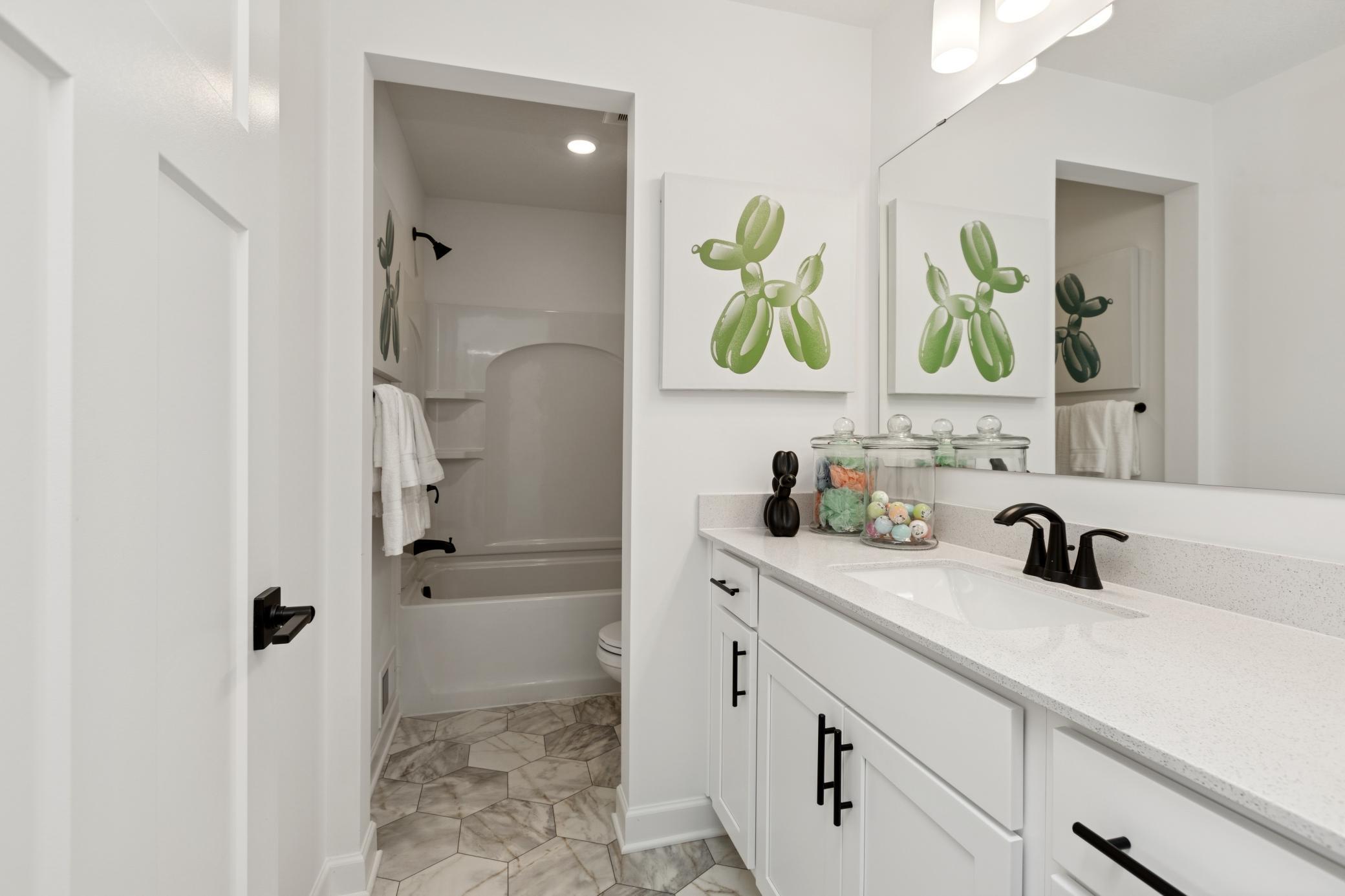 (Photo of Actual Model Home) This full bathroom features a wide single vanity and shower-tub combination..jpg