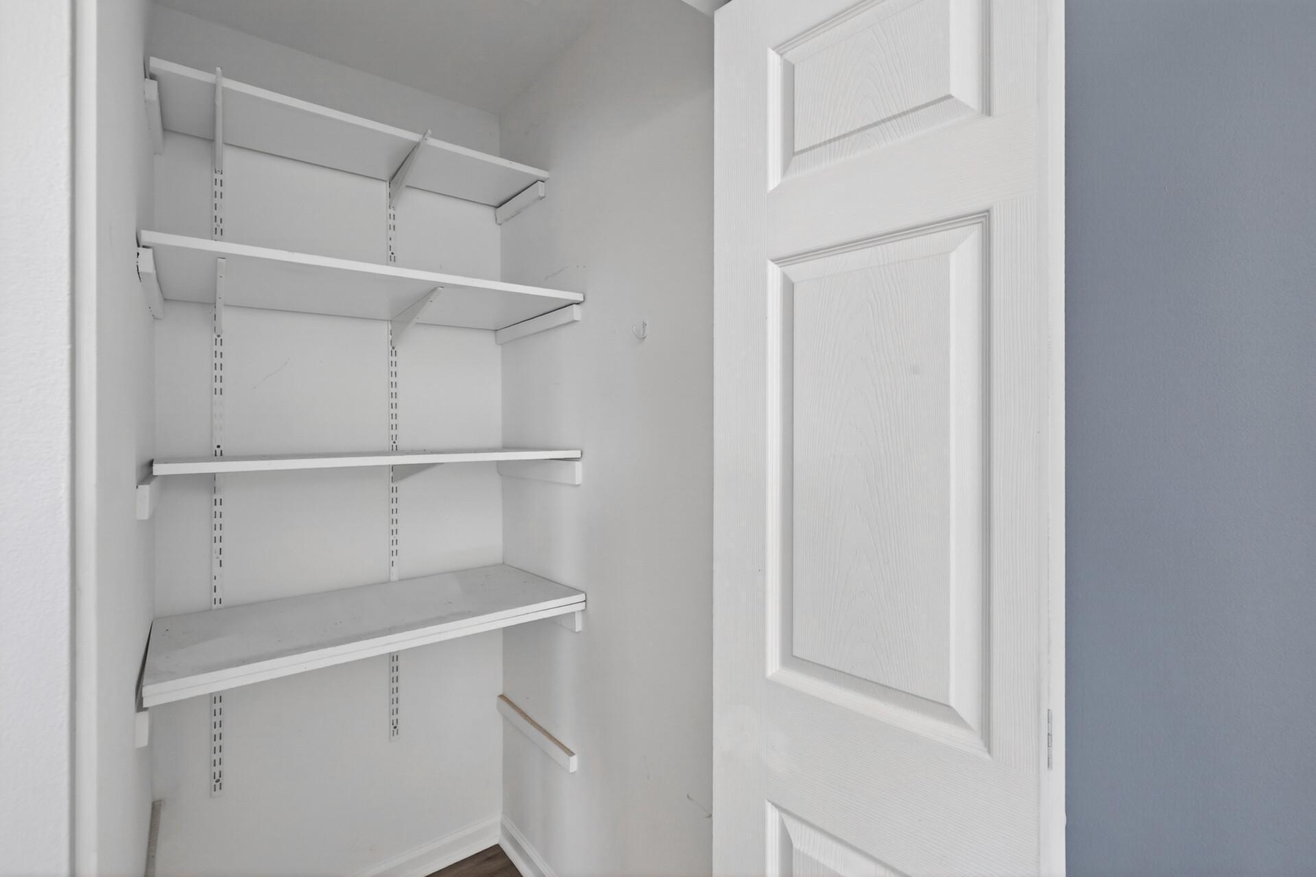 Pantry or storage closet with adjustable shelving for organized everyday storage at top of stairs