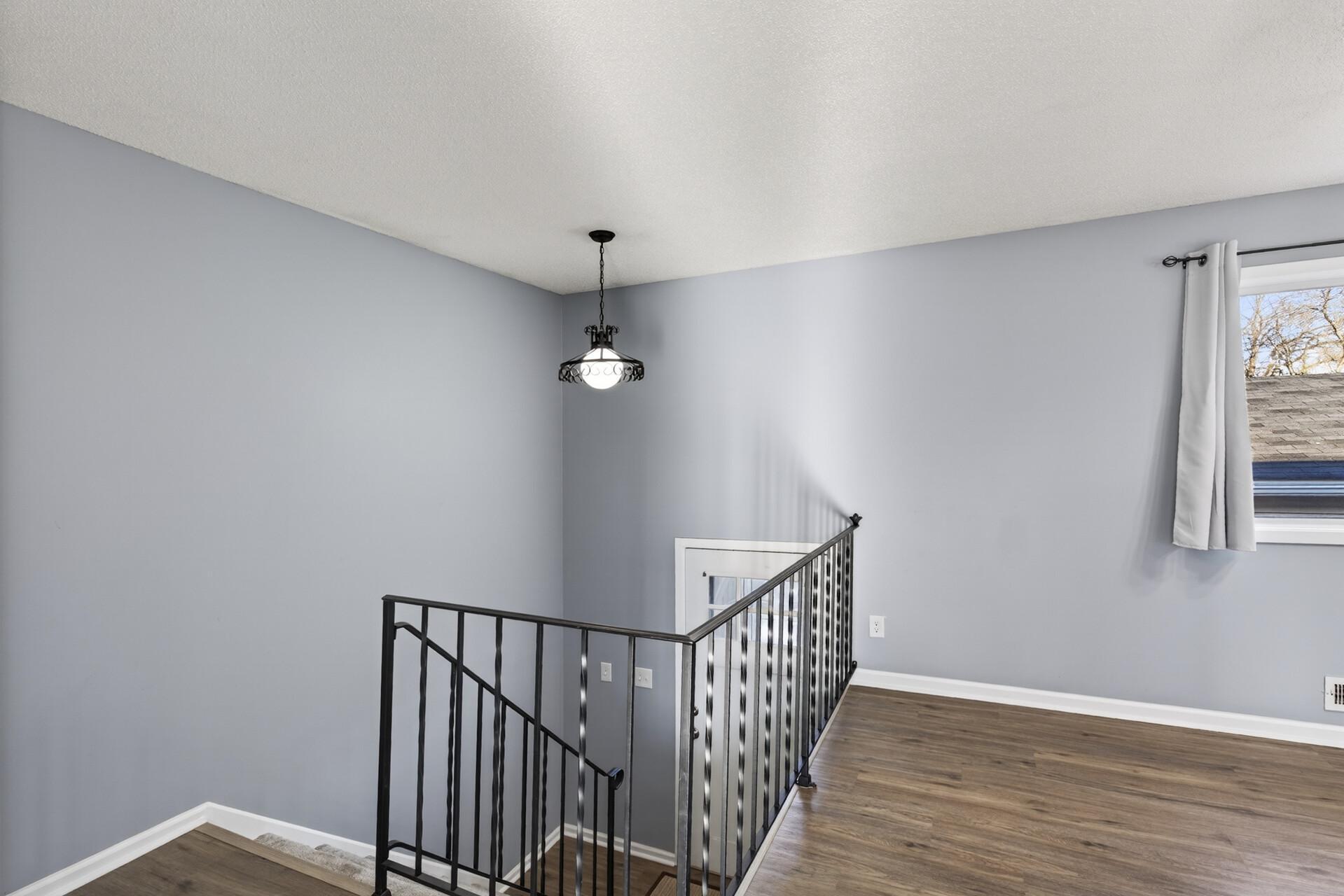 Upper-level landing with open sightlines, updated flooring, and bright natural light throughout.