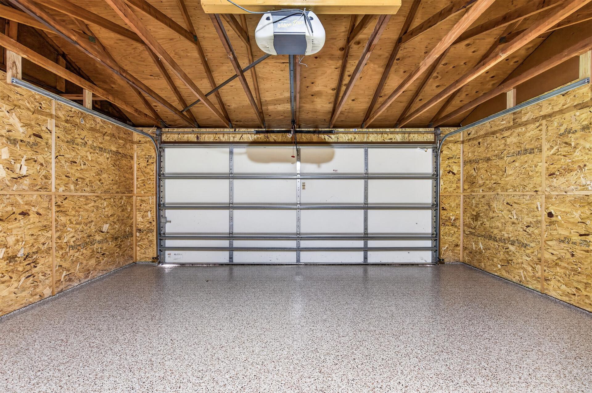 Detached two-car garage with coated flooring, ample storage potential, and room for vehicles, tools, or hobbies.