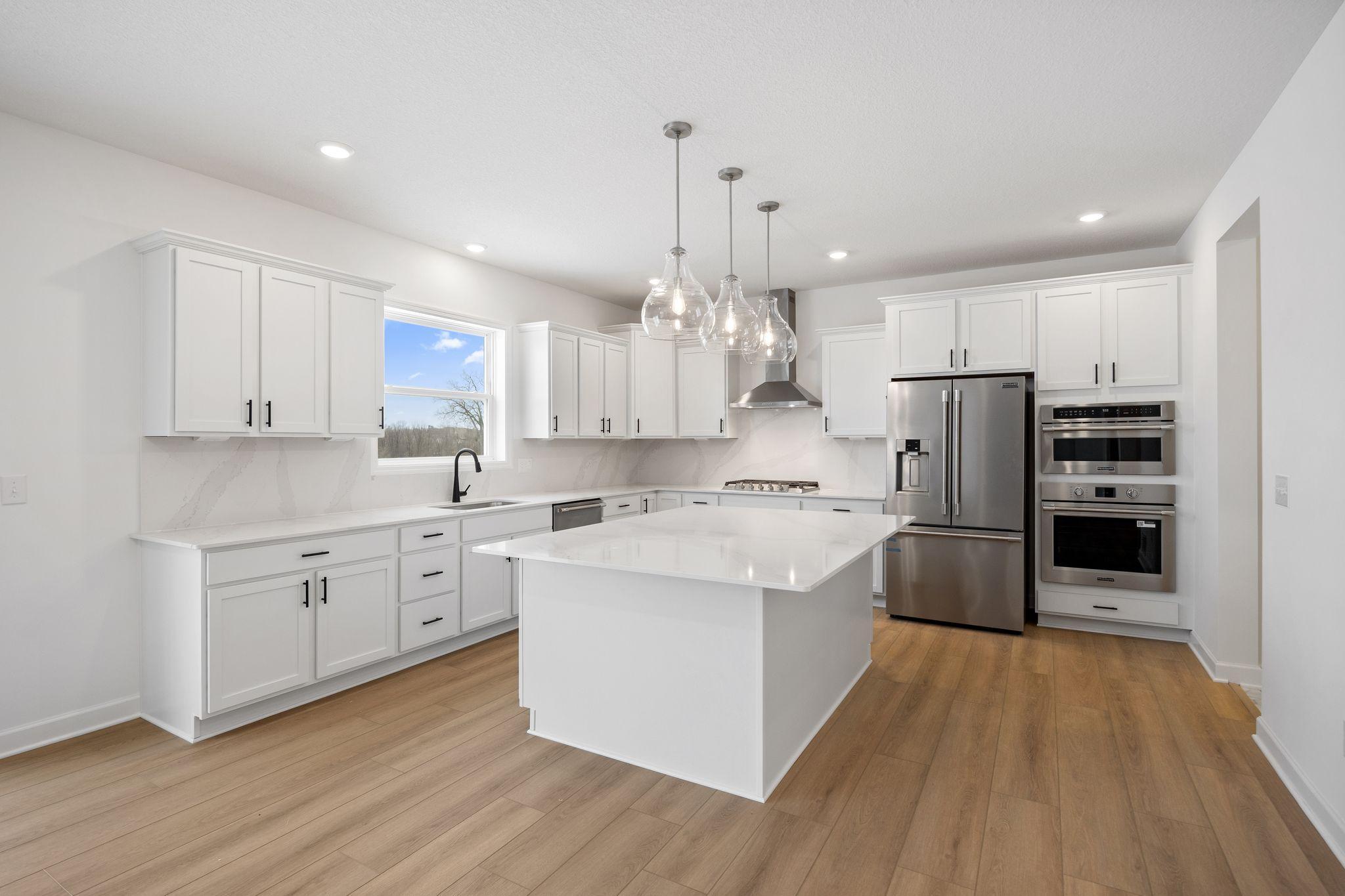 (Photo of a similar home, actual finishes may vary) The kitchen is equally stylish and practical with sleek cabinetry, high-end finishes and all-new stainless steel appliances.