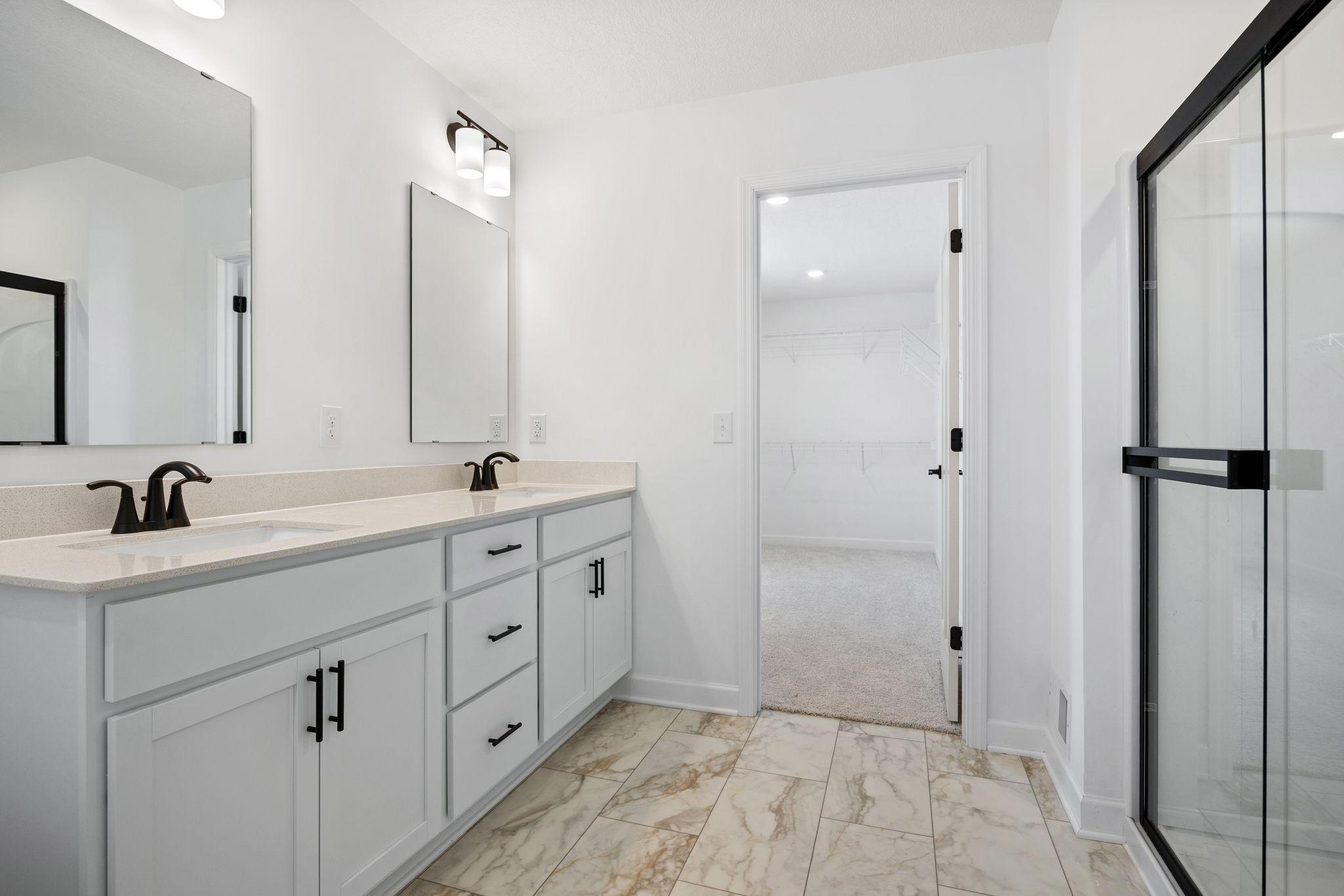 (Photo of a similar home, actual finishes may vary) Dual rectangular undermount sinks and chrome fixtures sit atop the stylish vanity to complement busy lifestyles