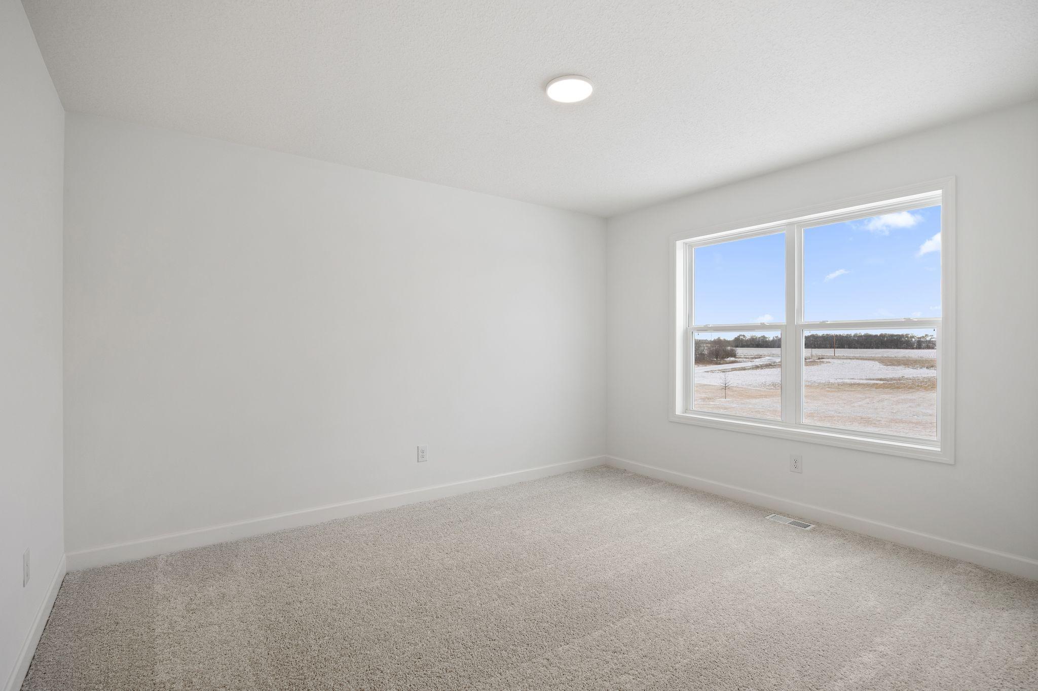 (Photo of a similar home, actual finishes may vary) Three secondary bedrooms are situated down the hall from the owner’s suite on the second floor.