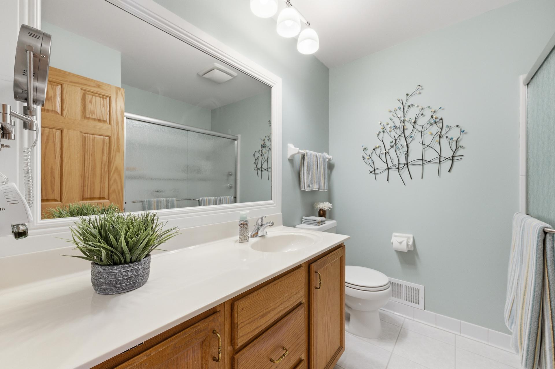 Main level bath with tile floor and solid surface countertop.