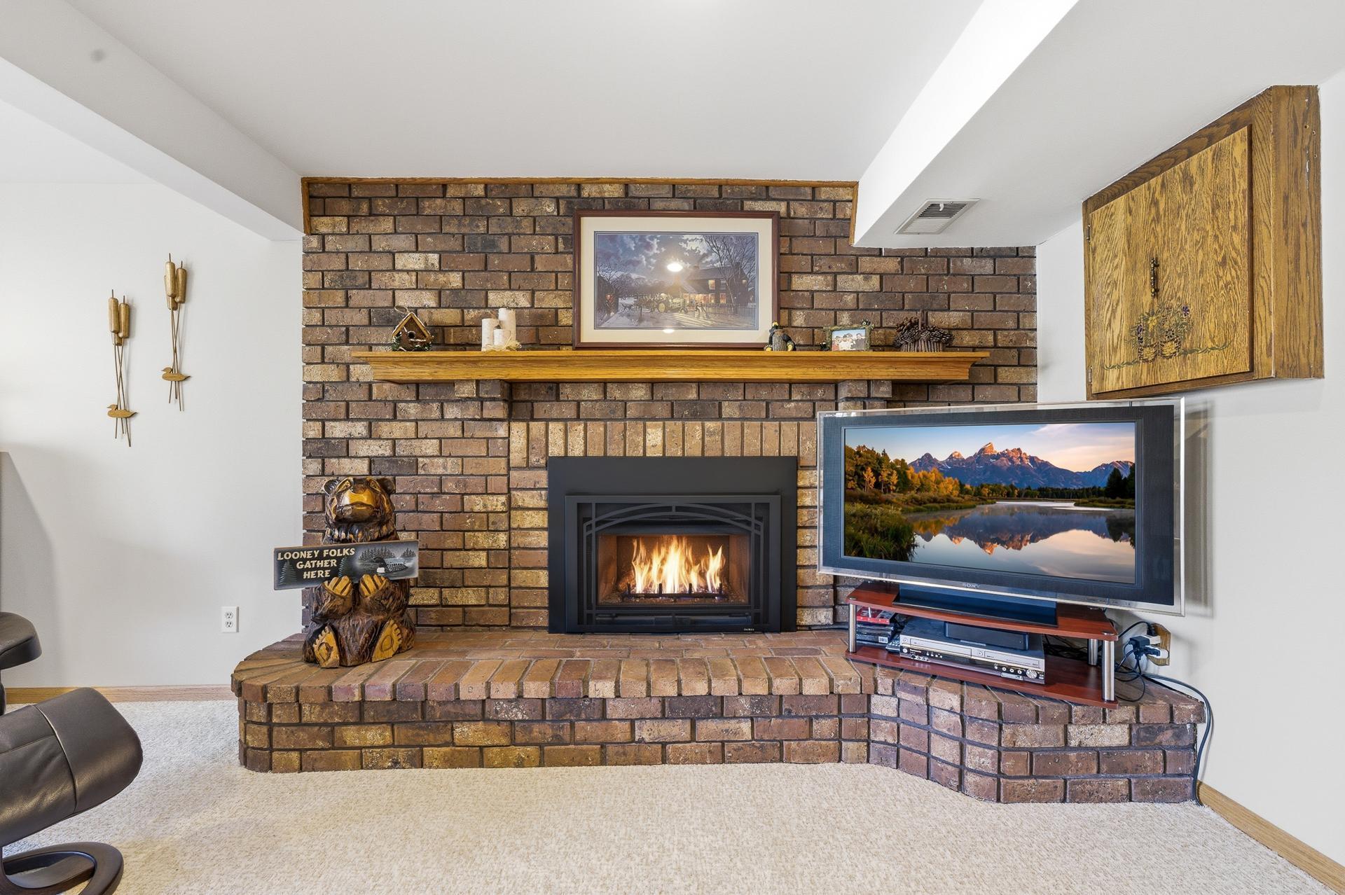 Brick fireplace surround with gas log set.