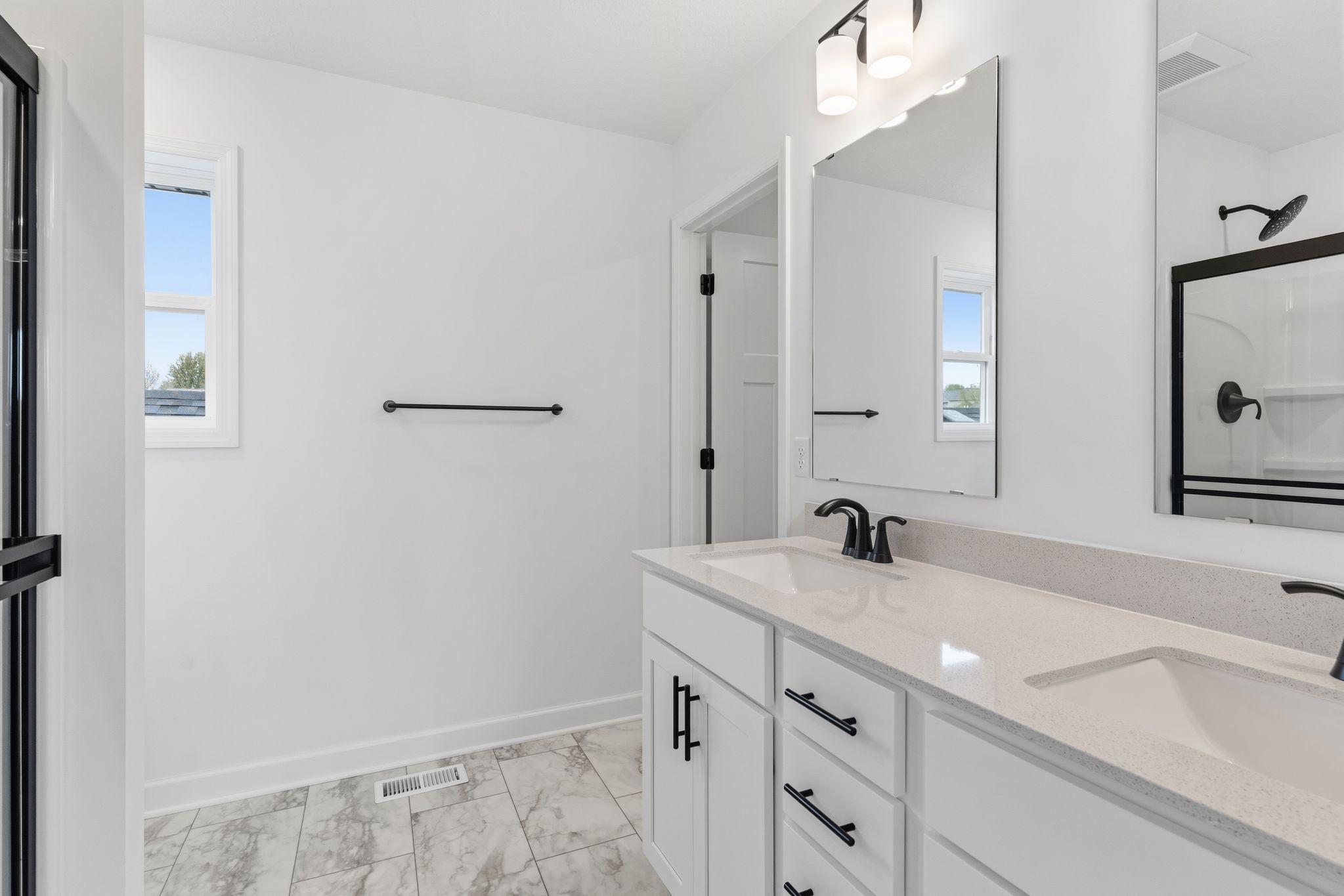 Rectangular dual sinks at this spacious quartz-topped vanity promote streamlined morning routines