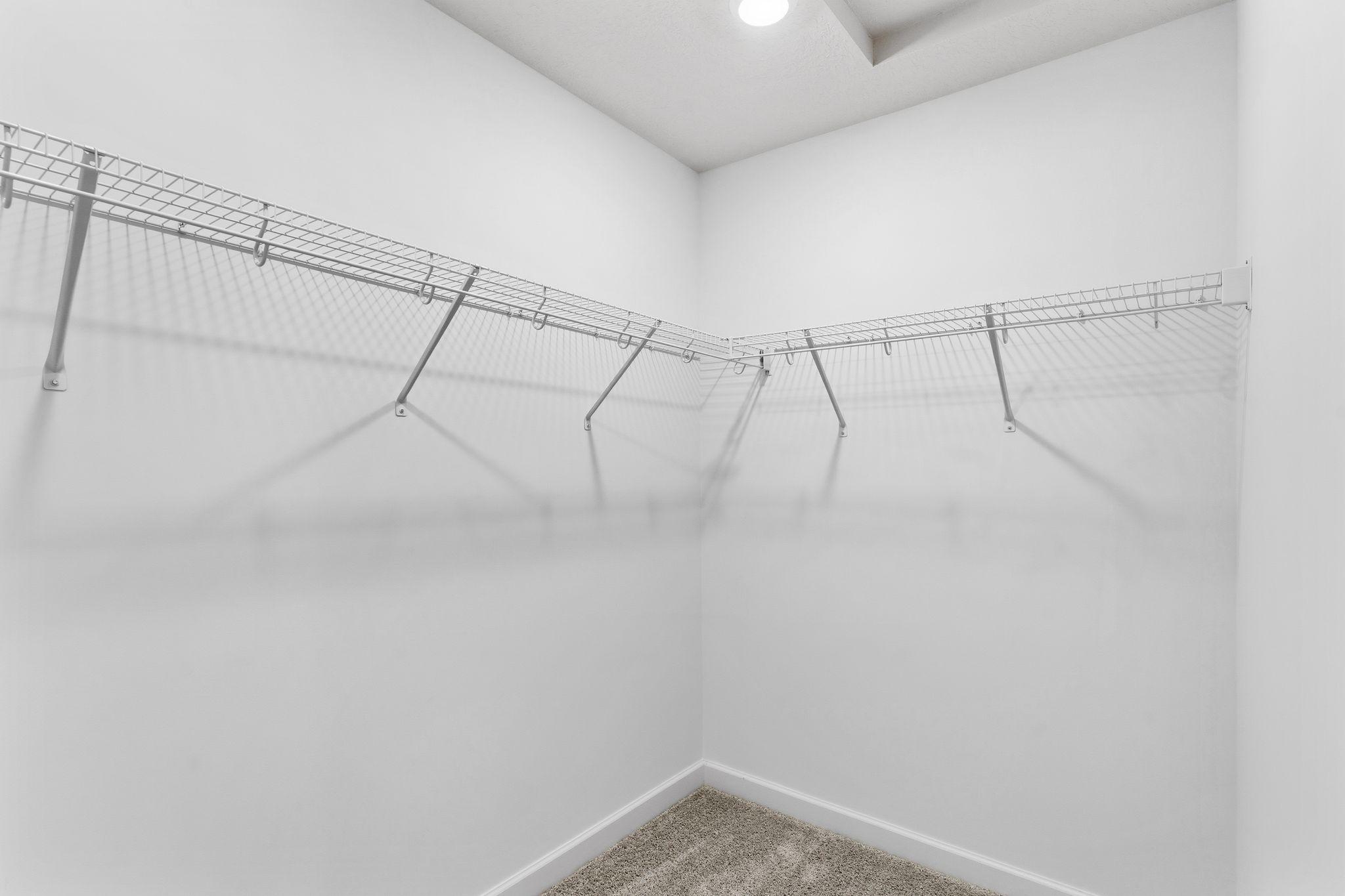 Wire shelving is included in this large walk-in closet, which provides ample wardrobe space