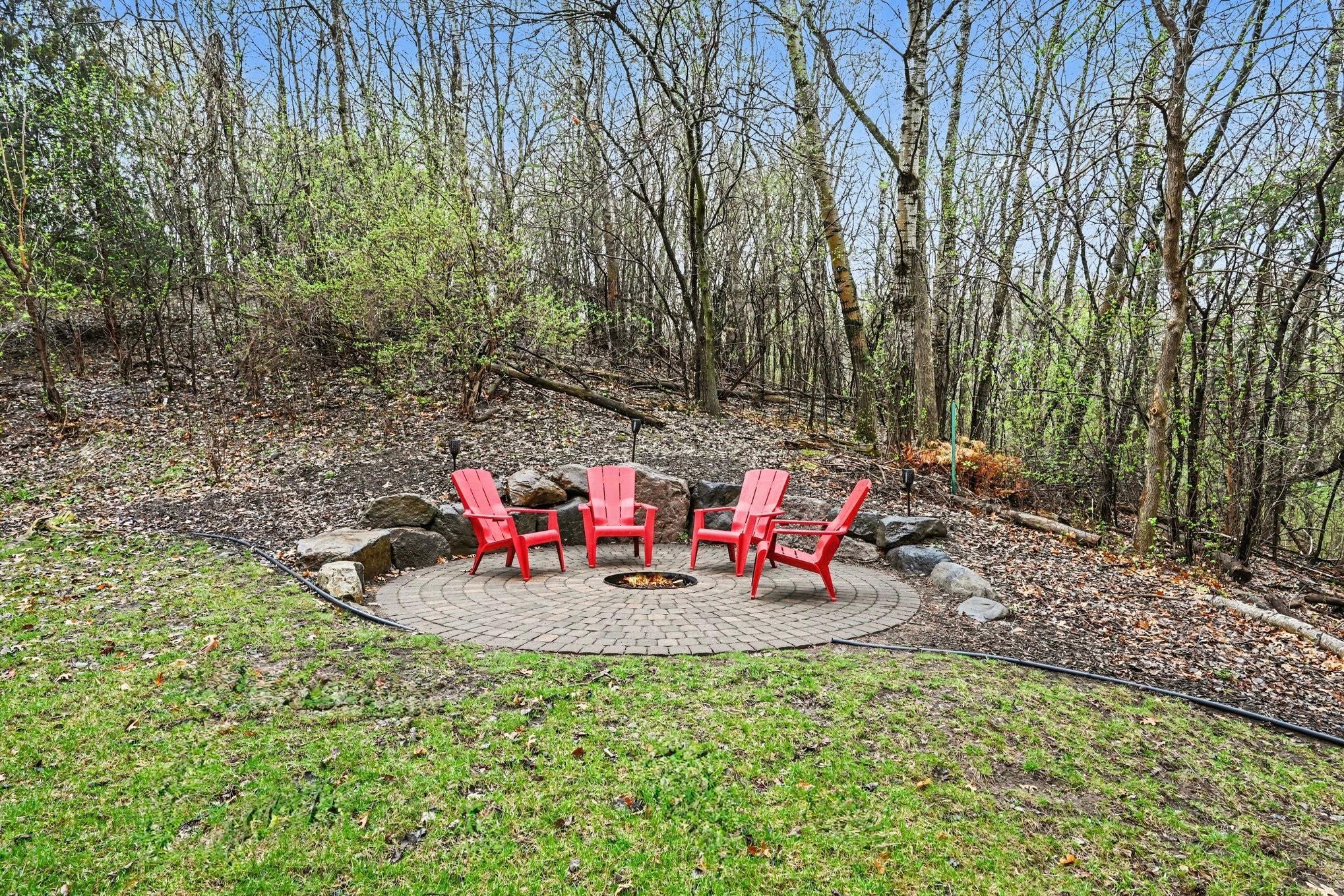 A paver and stone campfire pit creates a charming backyard focal point.