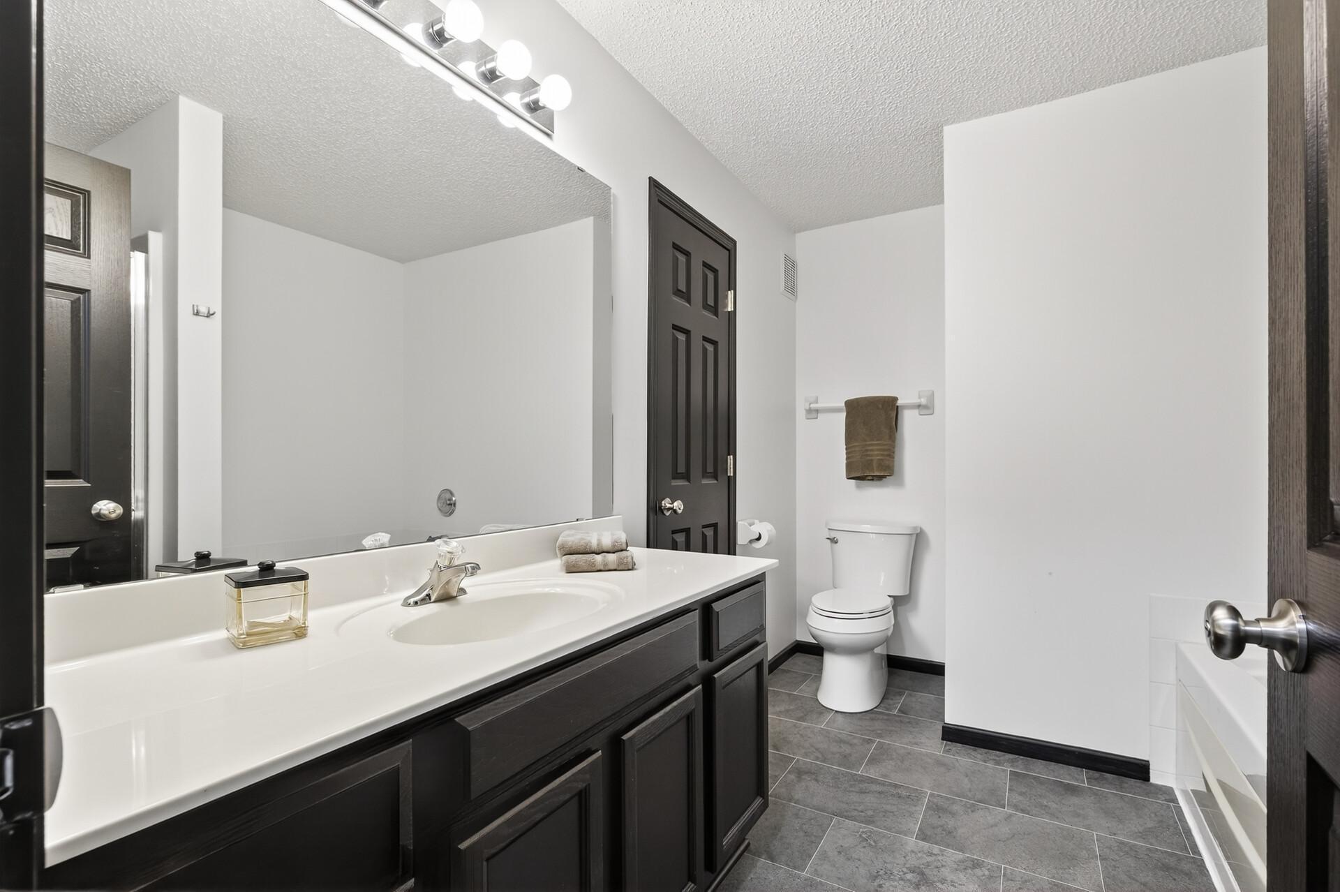 Primary walk-through bath on upper level with tub and separate shower