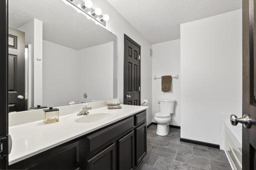 Primary walk-through bath on upper level with tub and separate shower