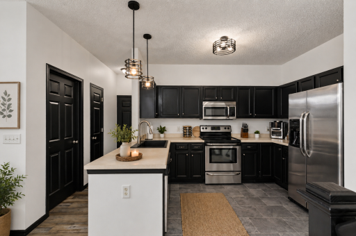 Kitchen is open to the large vaulted living room space with expansive windows filling it with natural light.