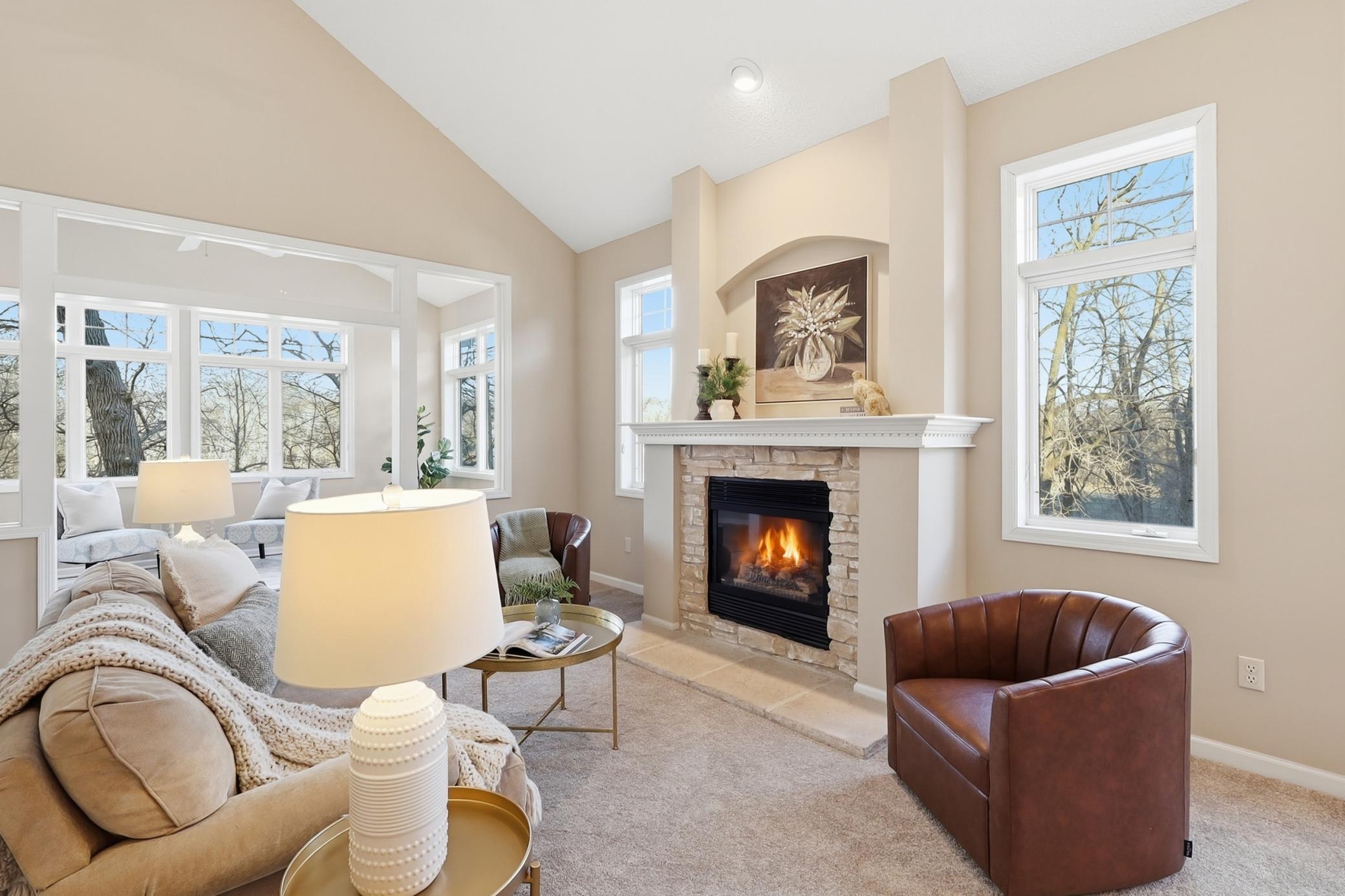 This gas fireplace anchors this living space and is flanked by windows all around.