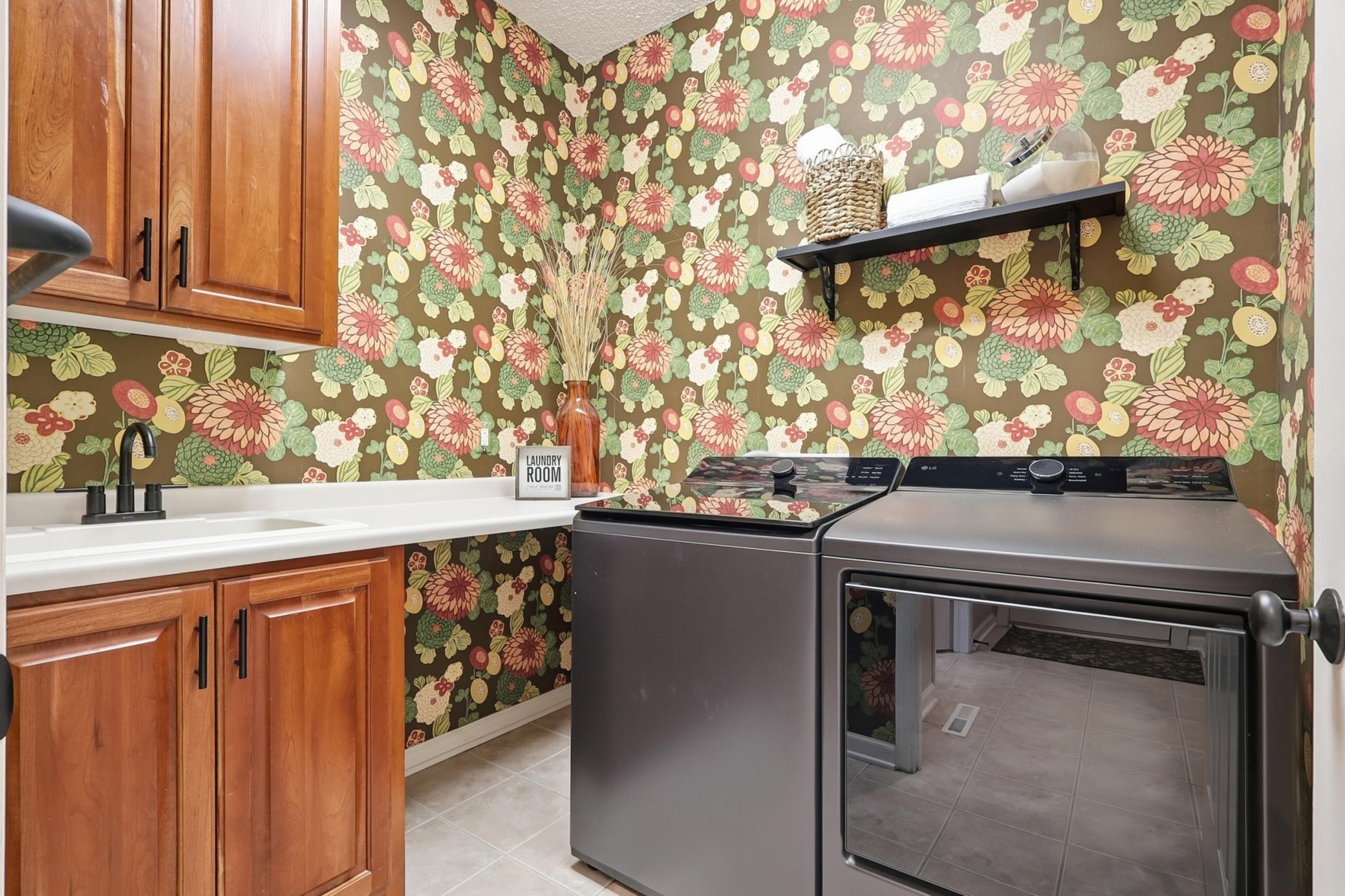 Charm filled laundry has built in cabinetry and deep sink with plenty of counterspace. Brand new black washer and dryer too!